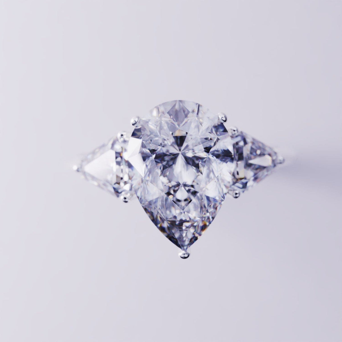 Silver-toned ring with a large pear-shaped center gemstone flanked by two triangular side stones.