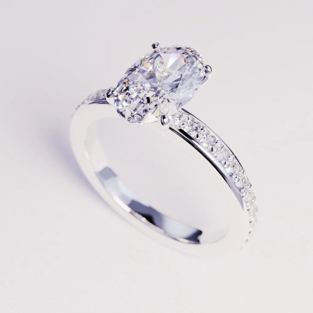 Oval-cut clear center set on a silver-toned pavé band, shown on a light background.