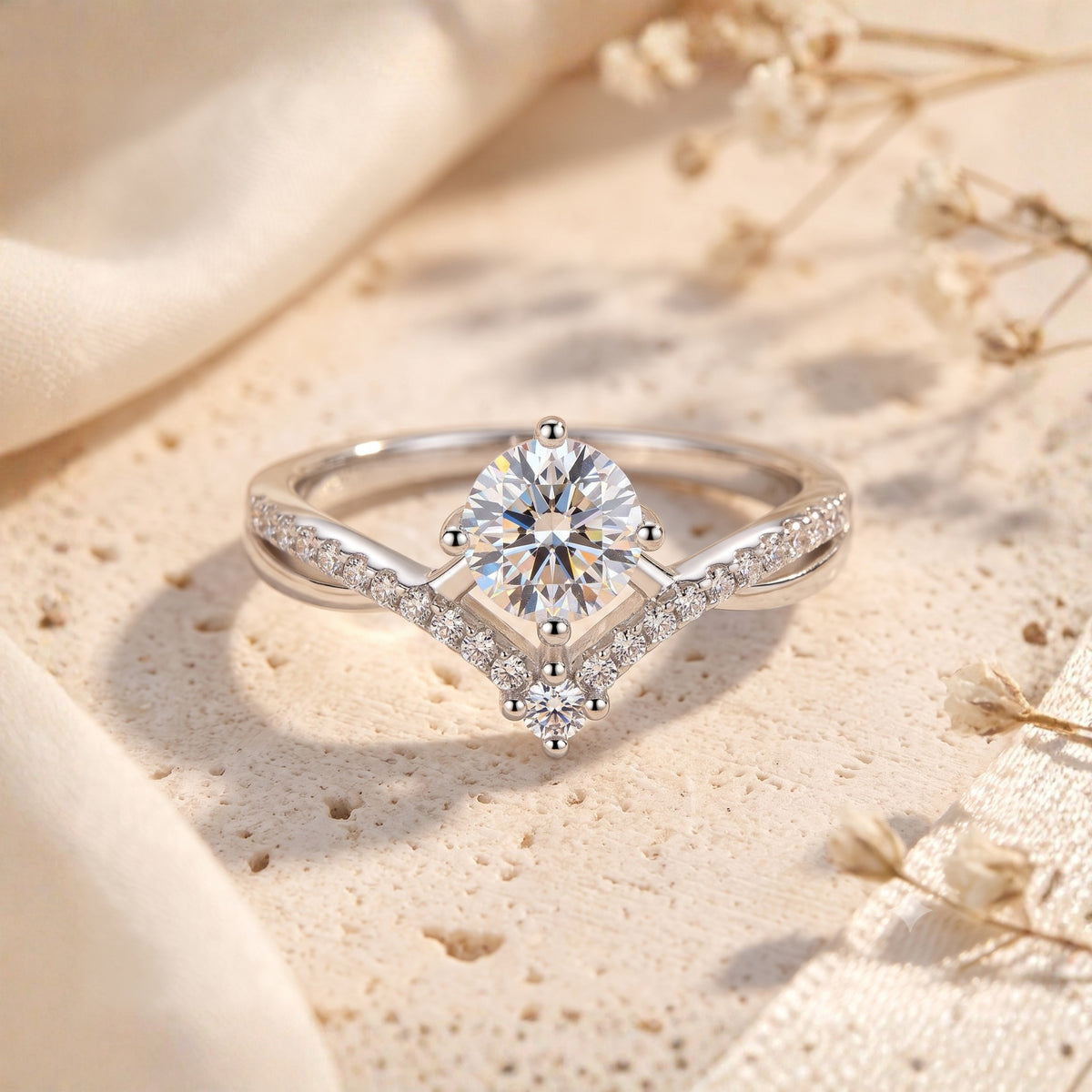 Silver chevron solitaire ring featuring a round center stone and pavé-set wishbone band on textured stone.