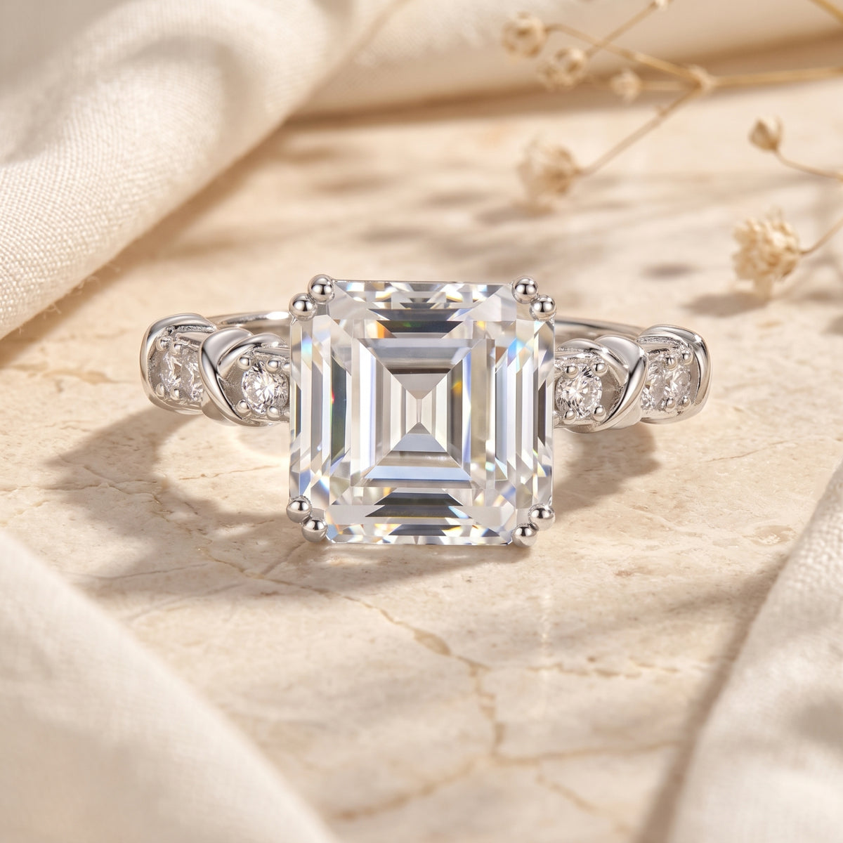 Front view of a silver ring with a large rectangular emerald-cut clear center stone and twisted accent band.