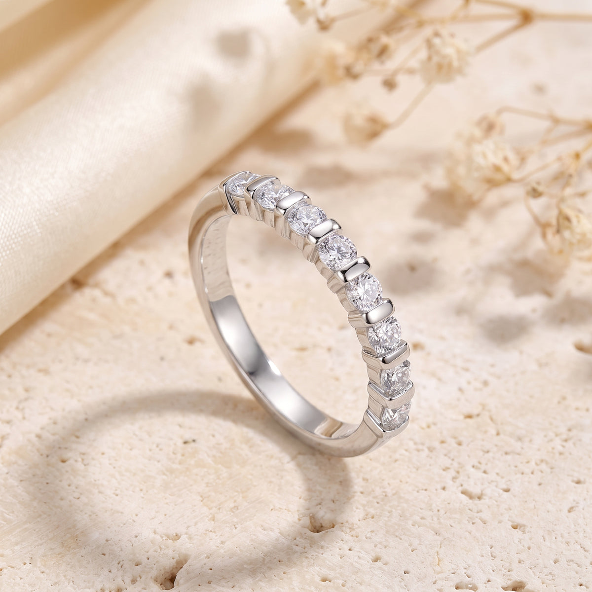 Angled upright view of a silver bar-set ring with round clear cubic zirconia stones.