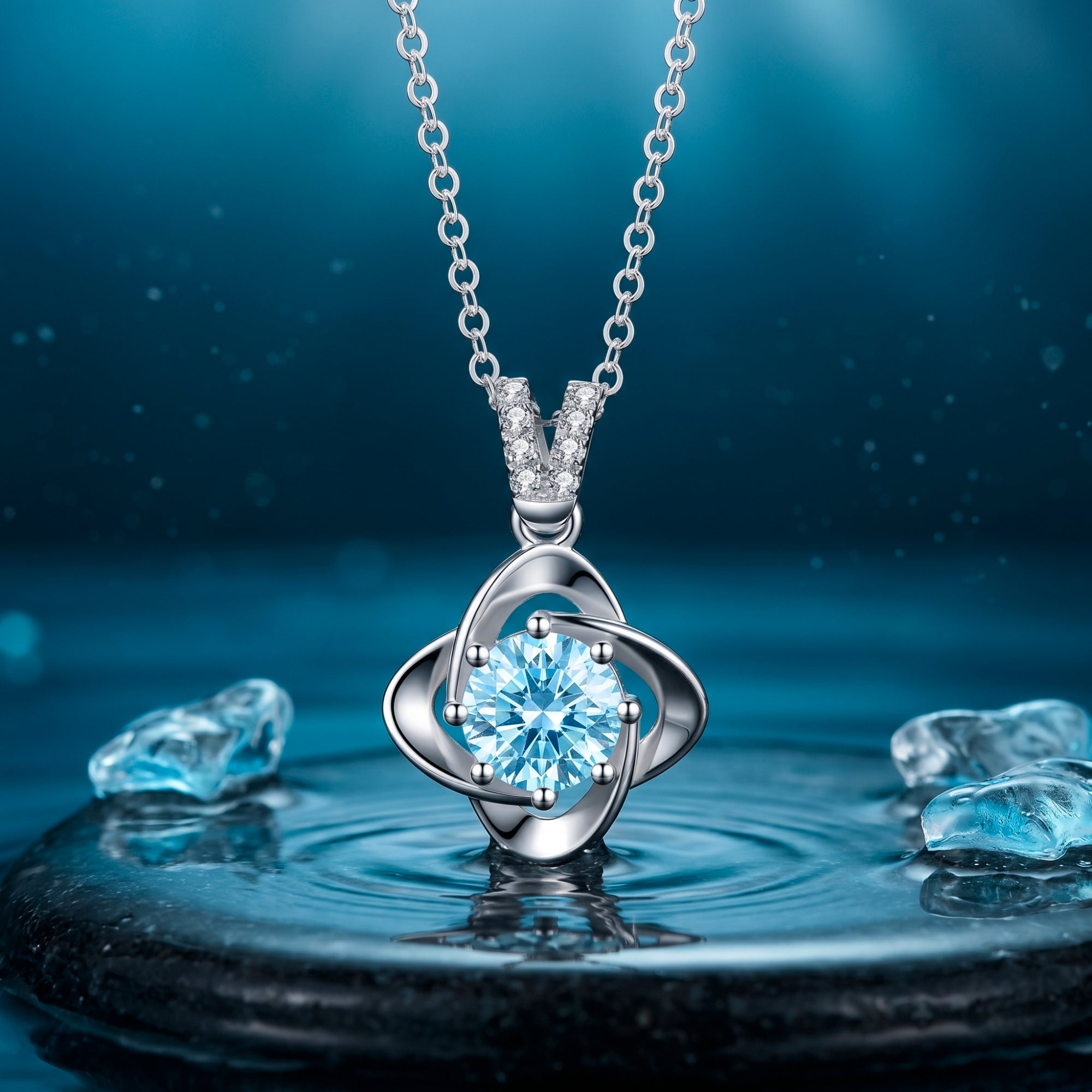 Round cut aquamarine pendant in platinum on a silver chain, displayed over water in a serene blue lifestyle setting.