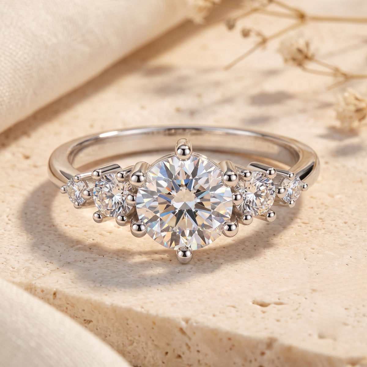Front view of a silver ring with a large round center stone and clustered side accents