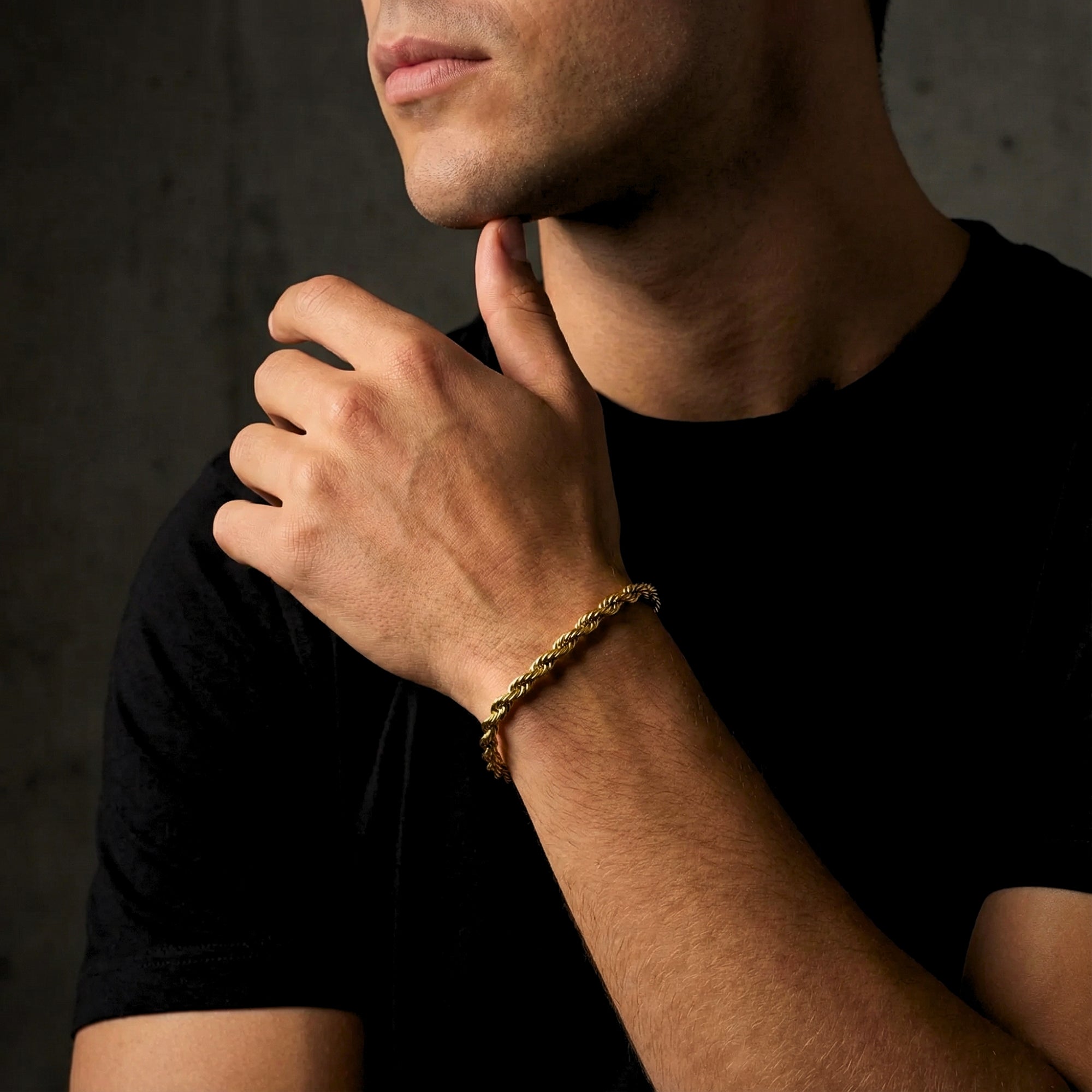 Gold stainless steel rope bracelet for men shown on a model's wrist, highlighting its subtle shine.