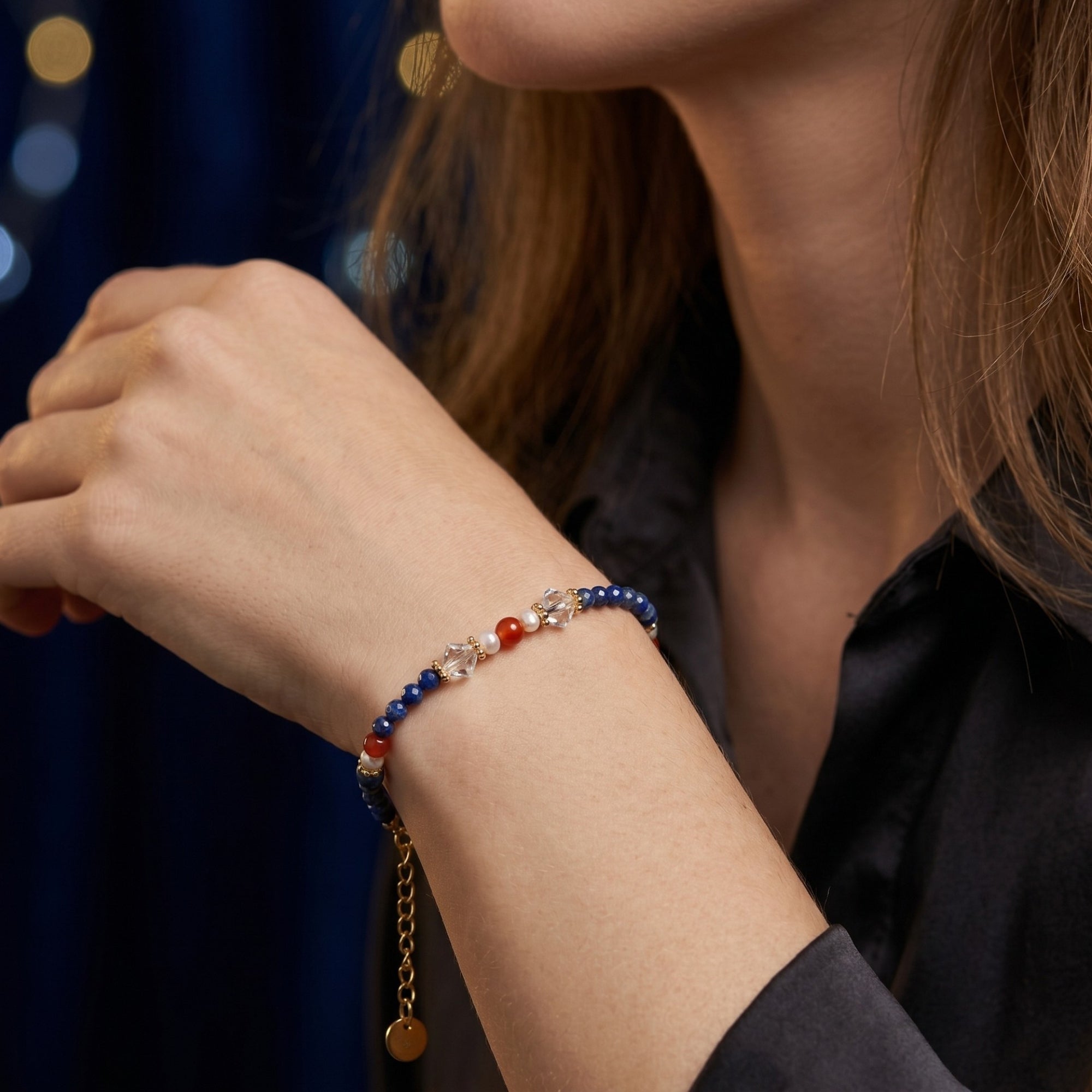 18K gold plated lapis lazuli bead bracelet with pearls and crystals worn on a model's wrist.