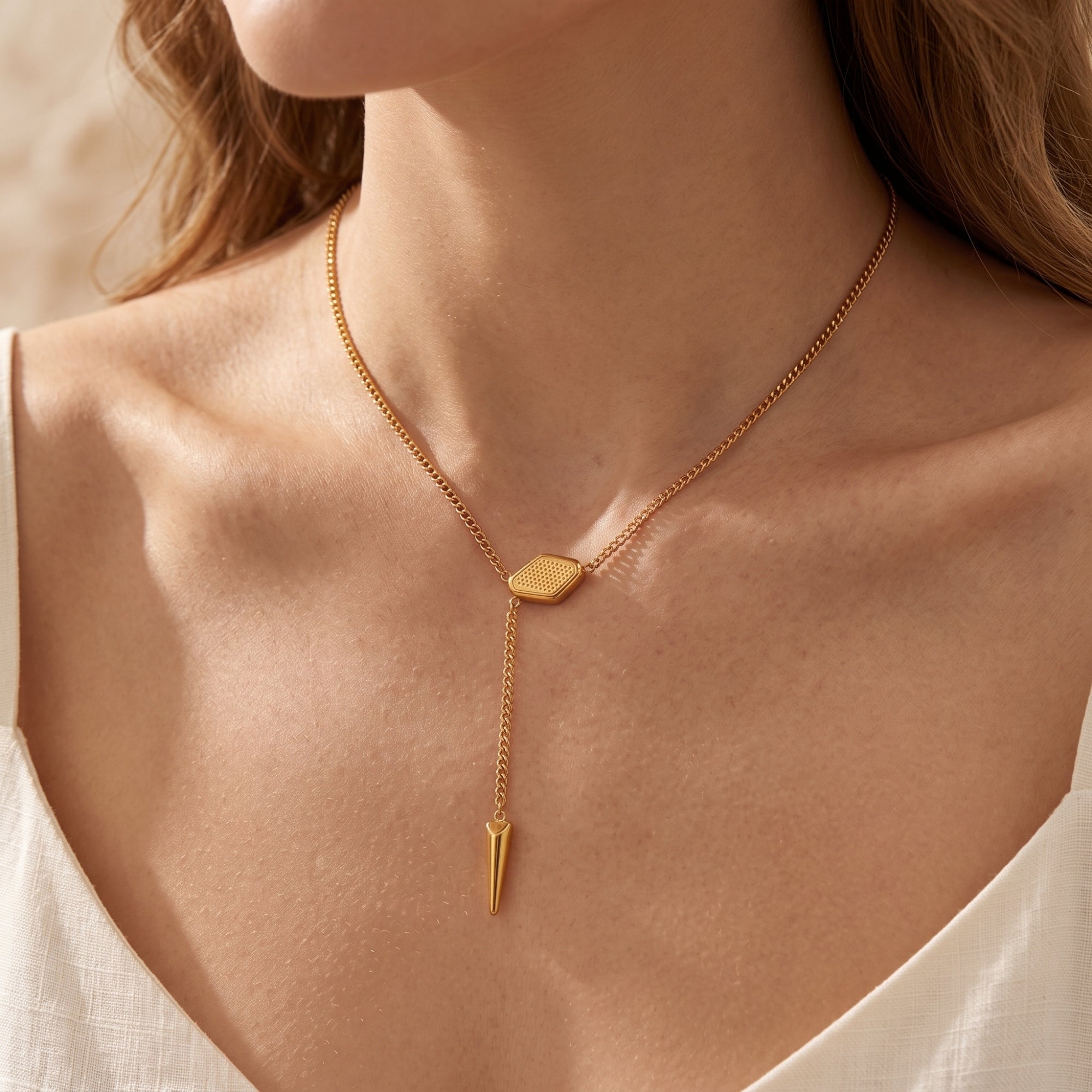 18K gold finish lariat necklace with geometric slider and spike pendant worn by a model.