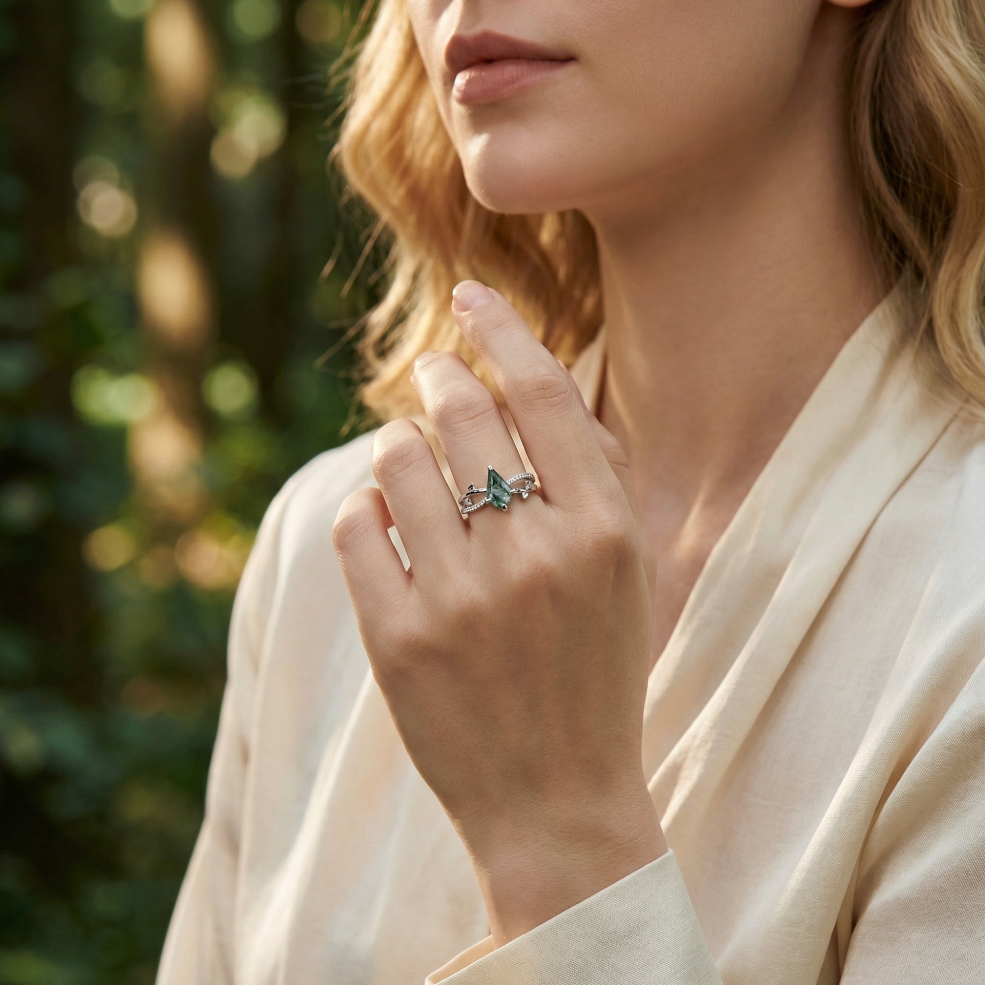 Model wearing a kite cut moss agate sterling silver ring with an intricate vine-inspired band.
