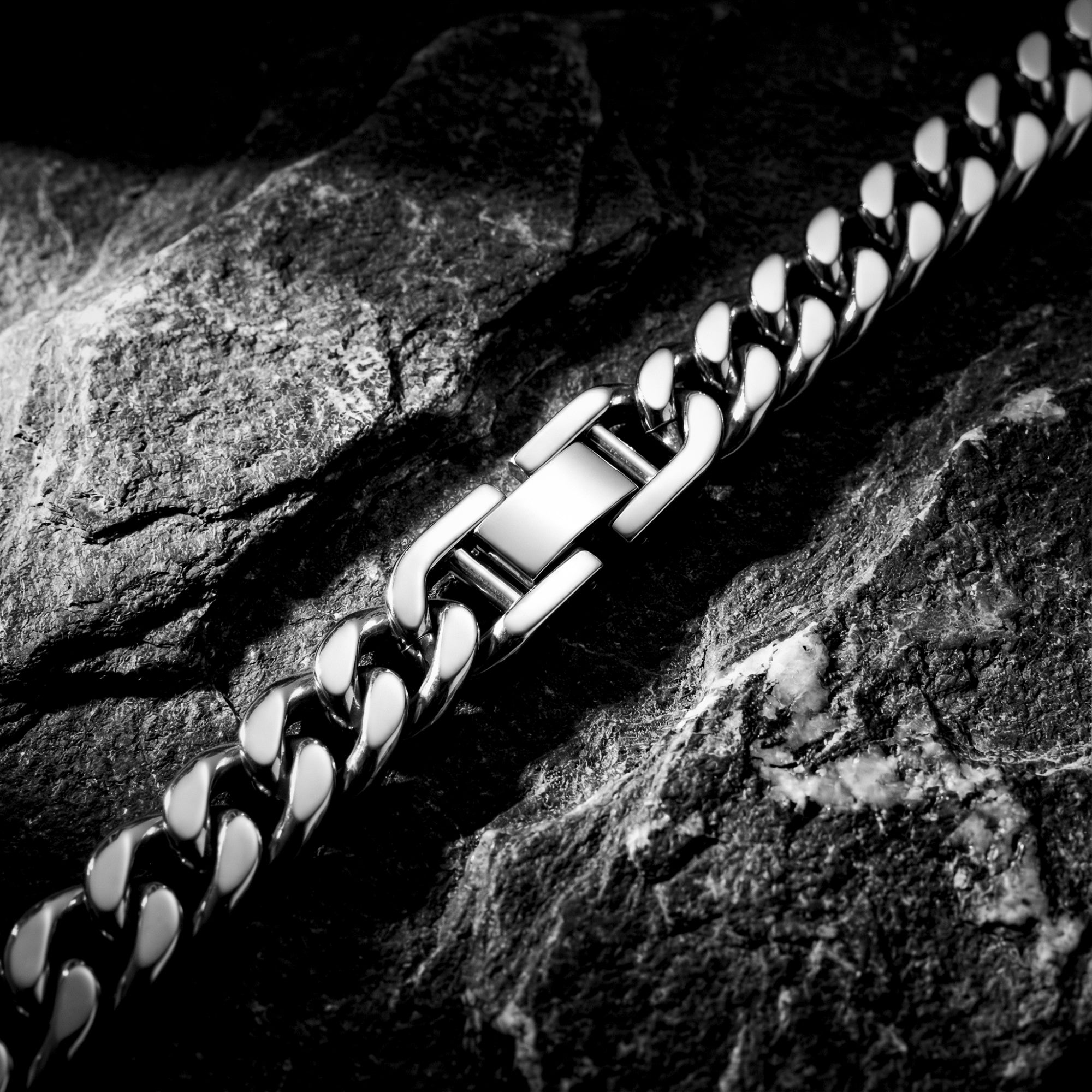Close-up of the secure clasp and polished links on a silver stainless steel men's Cuban link bracelet.
