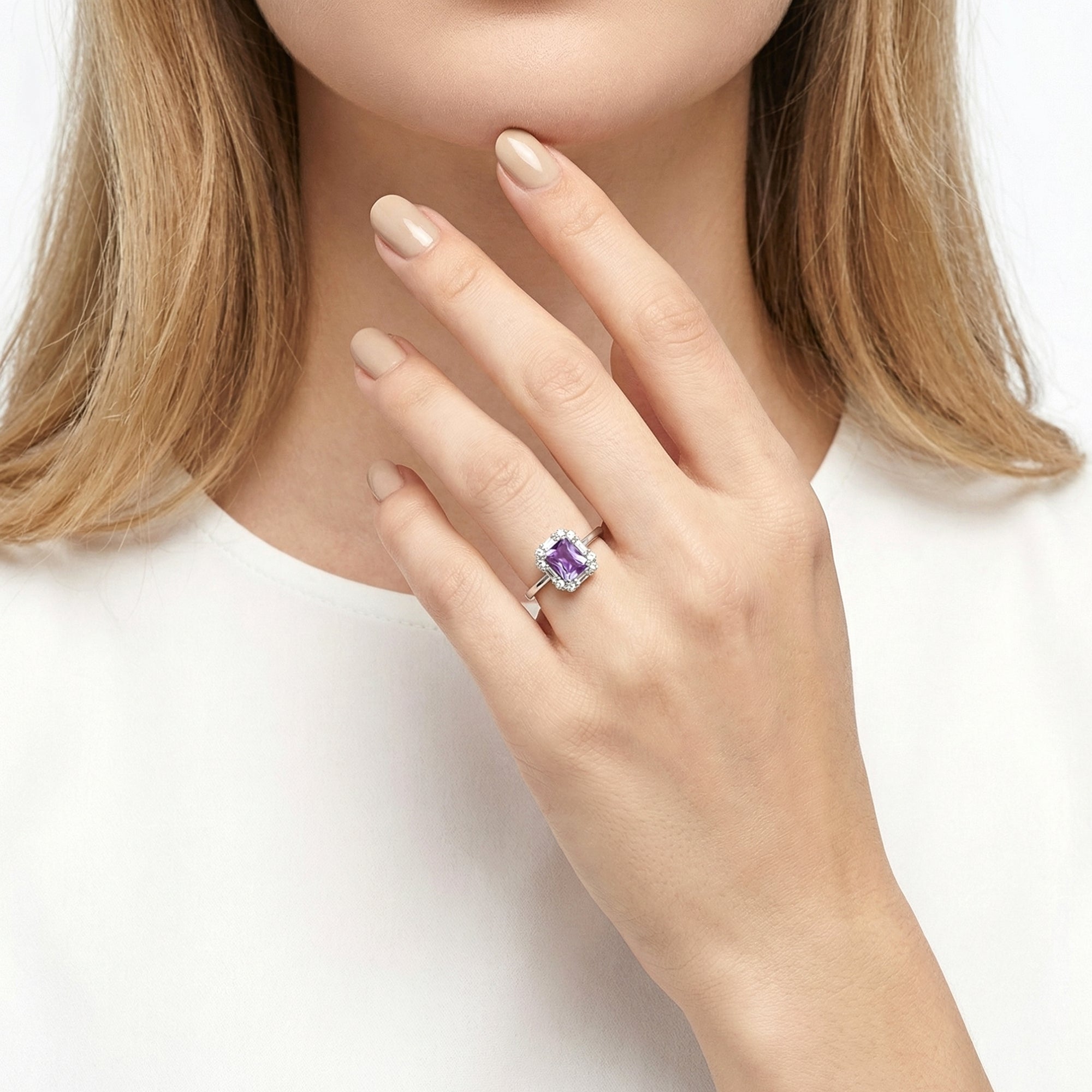 Model wearing the emerald cut simulated amethyst halo ring in sterling silver on her ring finger.