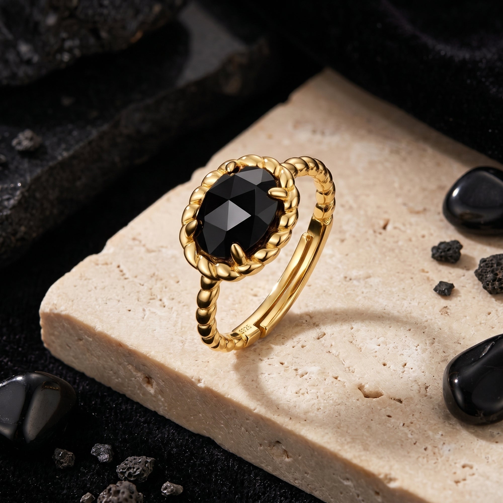 Close-up of the Calisto black onyx ring showing the 18K gold plated twisted band and faceted oval stone.
