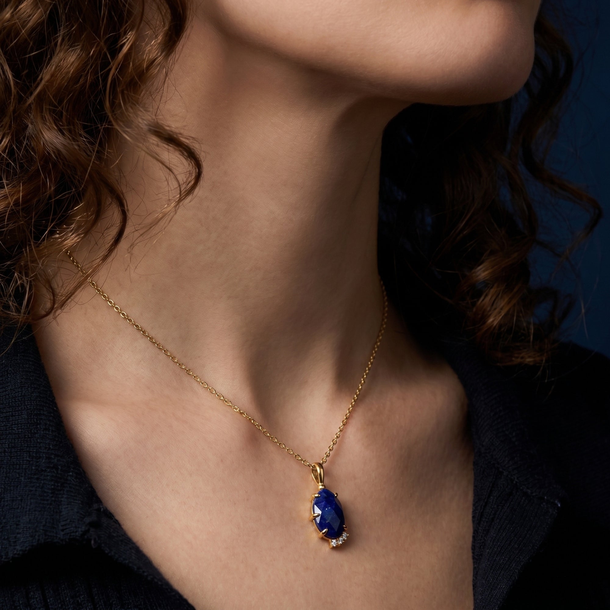 A woman wearing the Maia pear natural lapis lazuli necklace in 18k gold plated sterling silver.