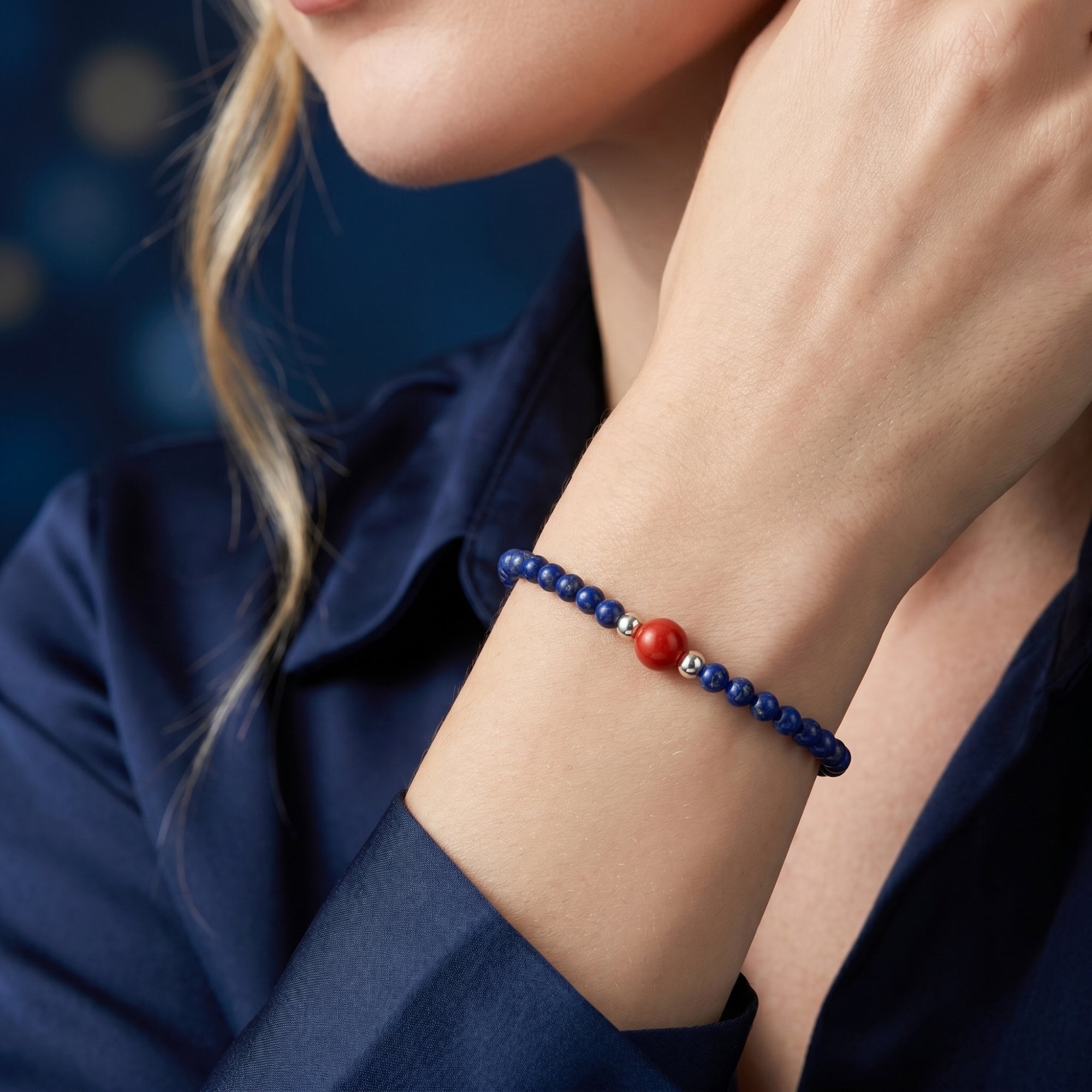 Model wearing the Azure Trace blue lapis and red bead bracelet in sterling silver on her wrist.