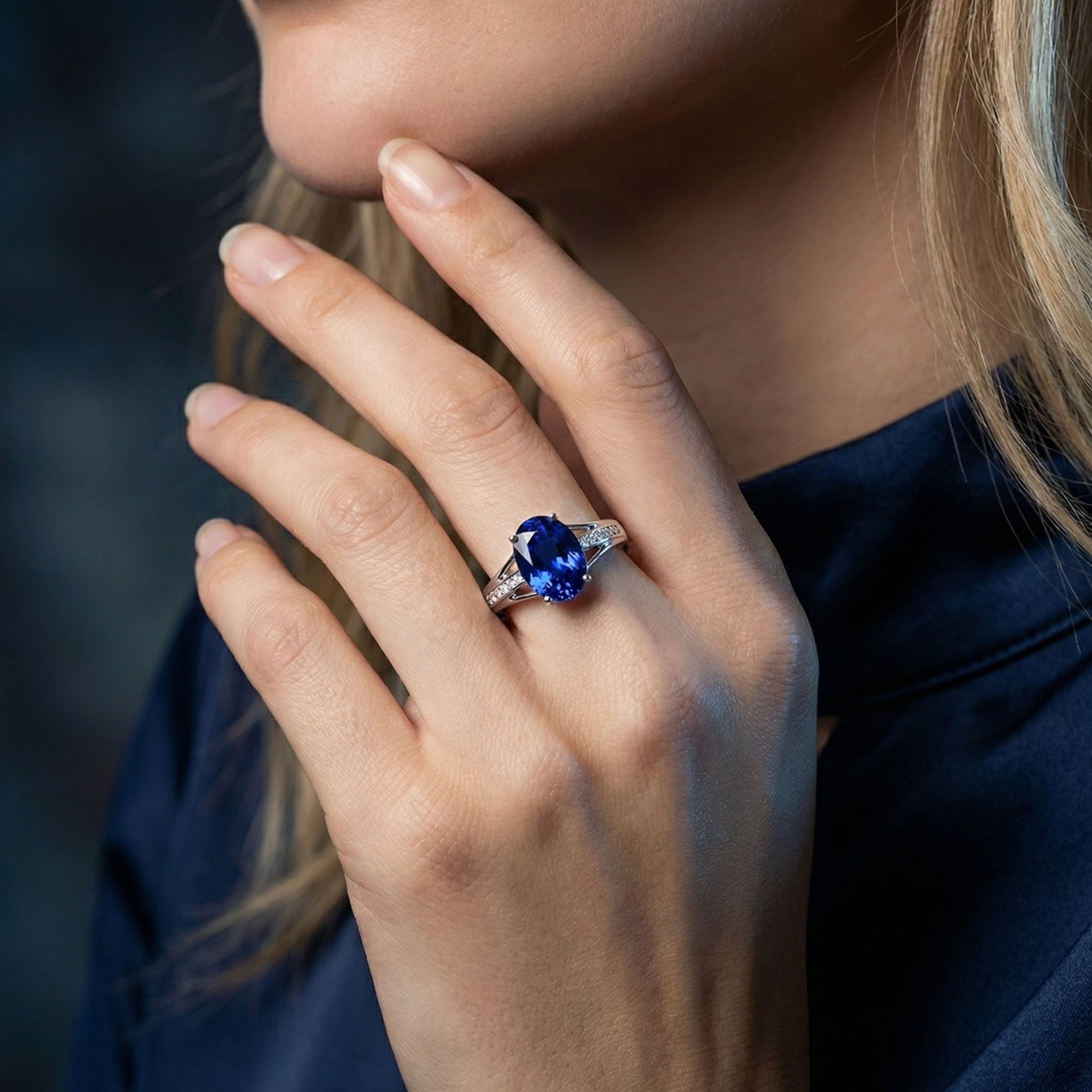 Model wearing the 18K white gold oval tanzanite and diamond ring, showing the gemstone's deep blue color.