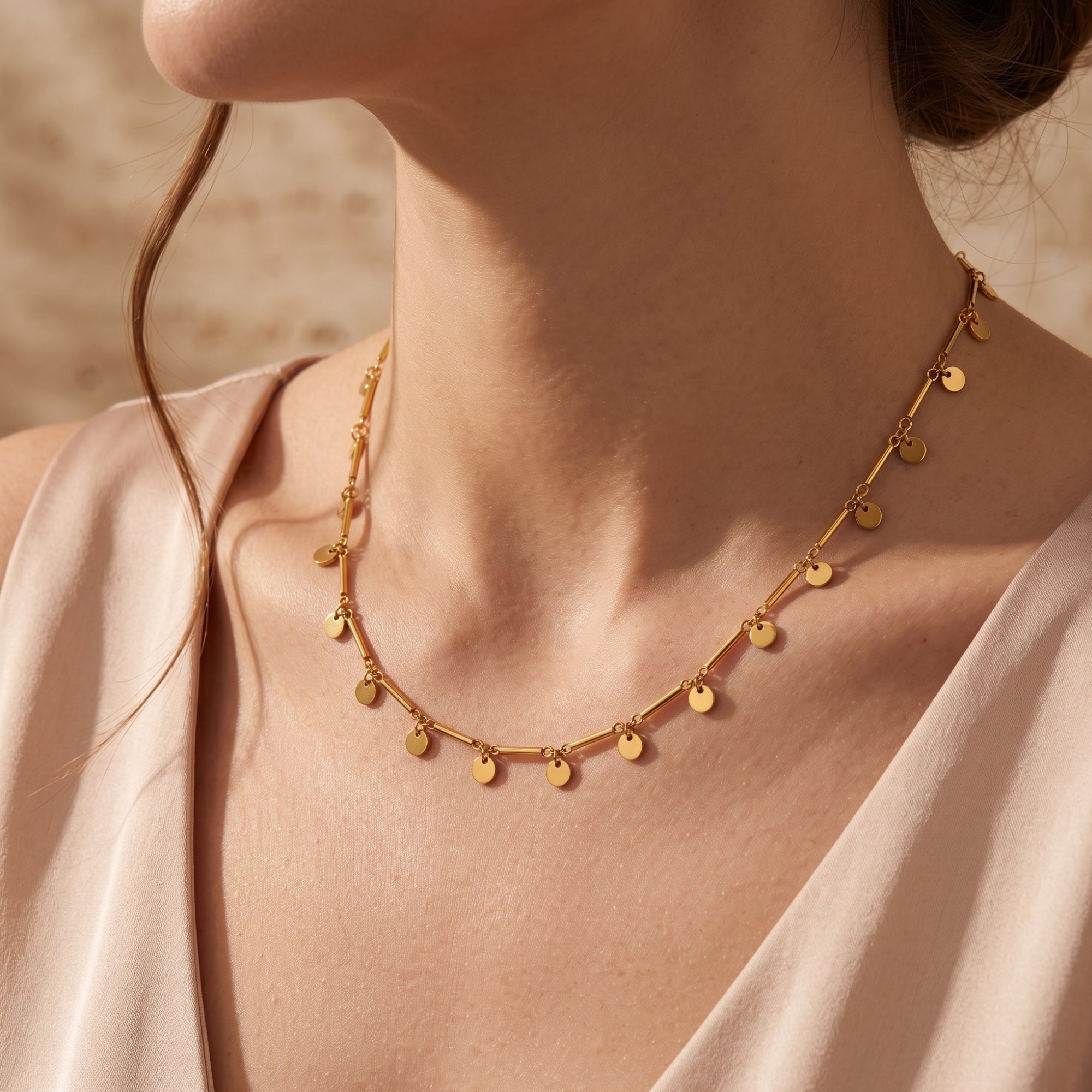 Shimmering gold disc necklace styled on a model.