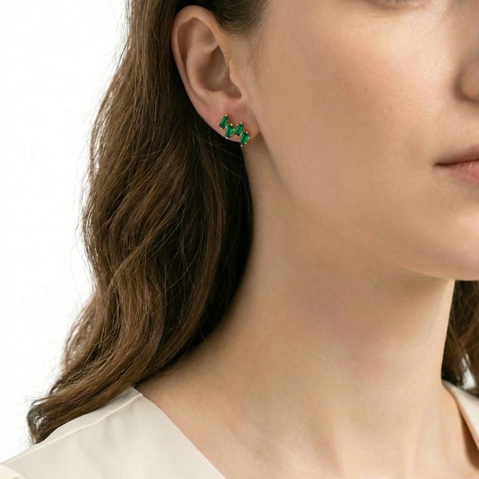 Side profile of a model wearing the Elaraea taper simulated emerald earrings in 18K gold vermeil.