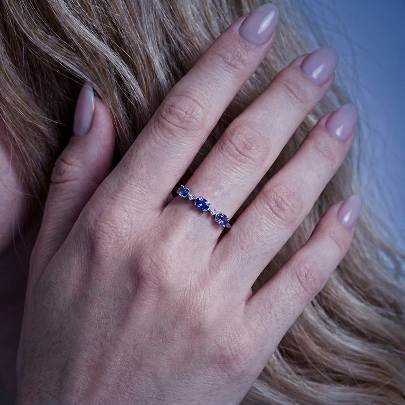 S925 sterling silver Marissara Trinity Ring with blue simulated tanzanite stones shown on a woman's hand for scale.