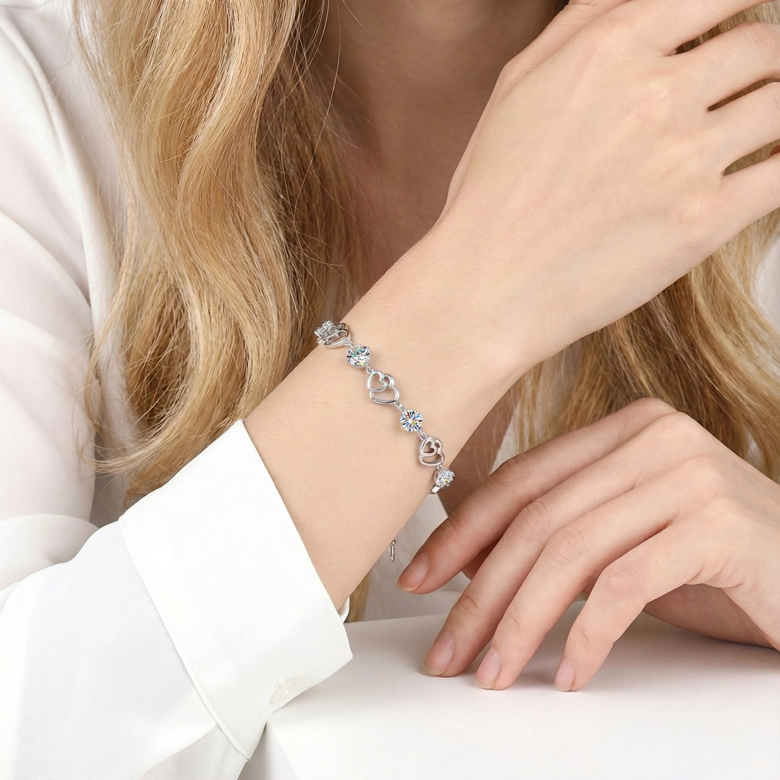 S925 sterling silver heart bracelet with round simulated diamonds worn on a woman's wrist for scale and style.