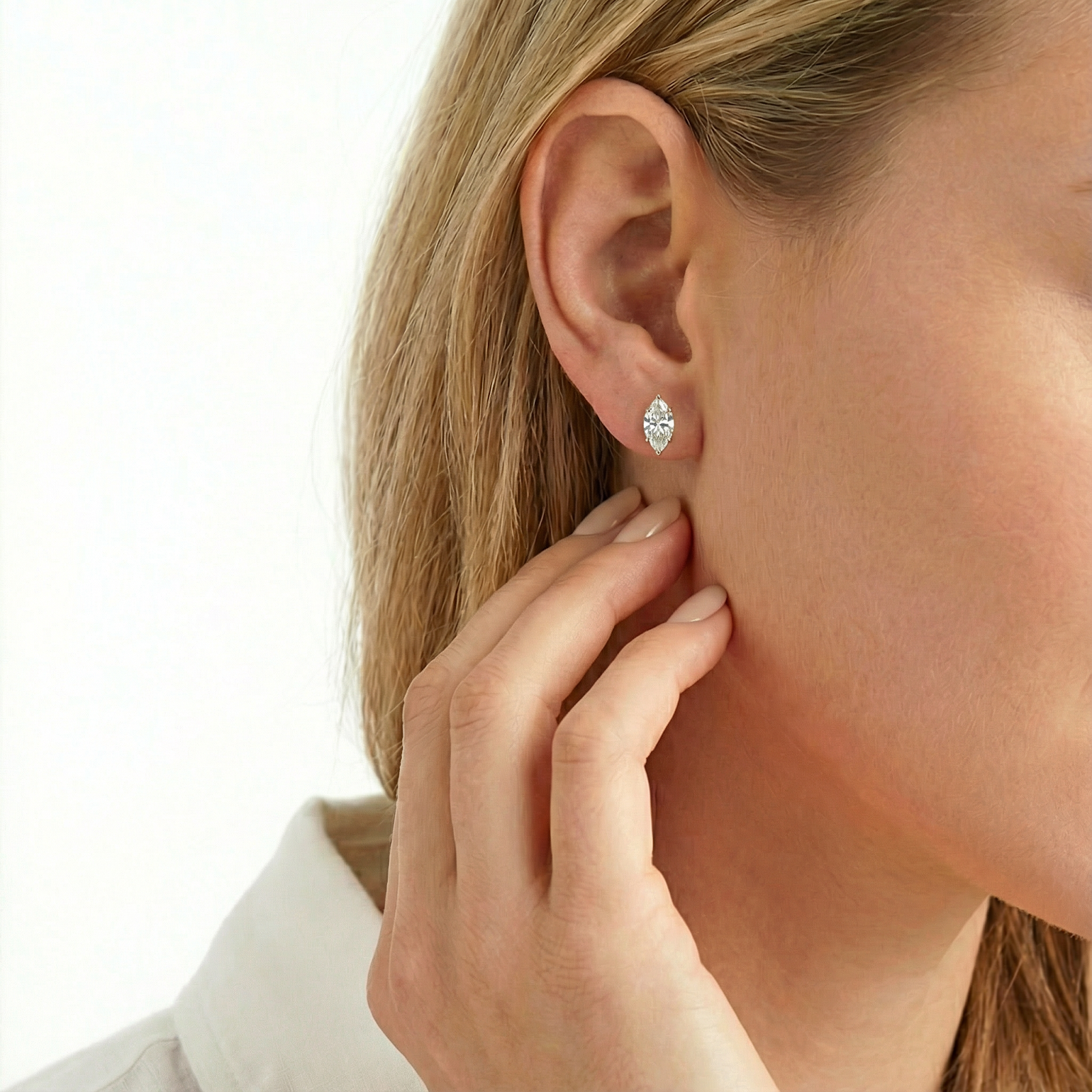 Close-up of a marquise-cut simulated diamond stud earring in 18K gold vermeil on a model's ear.