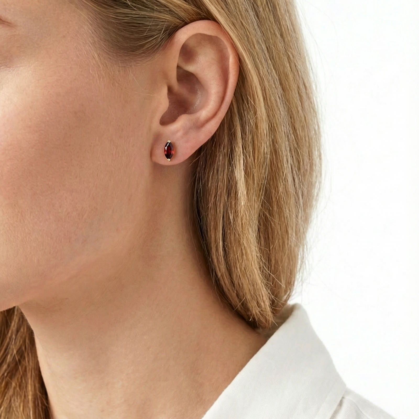 Model wearing a marquise cut simulated garnet stud earring in 18K gold vermeil.