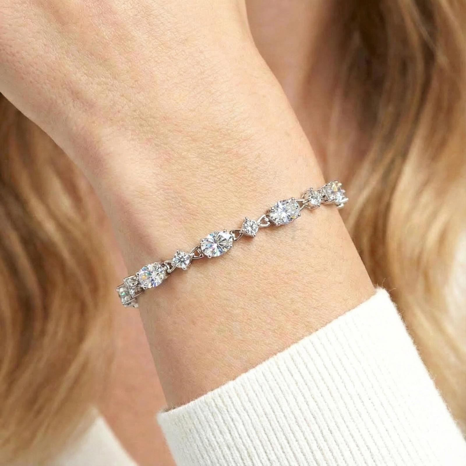 Macro view of the alternating round and oval-cut zirconia stones on a sterling silver station bracelet.