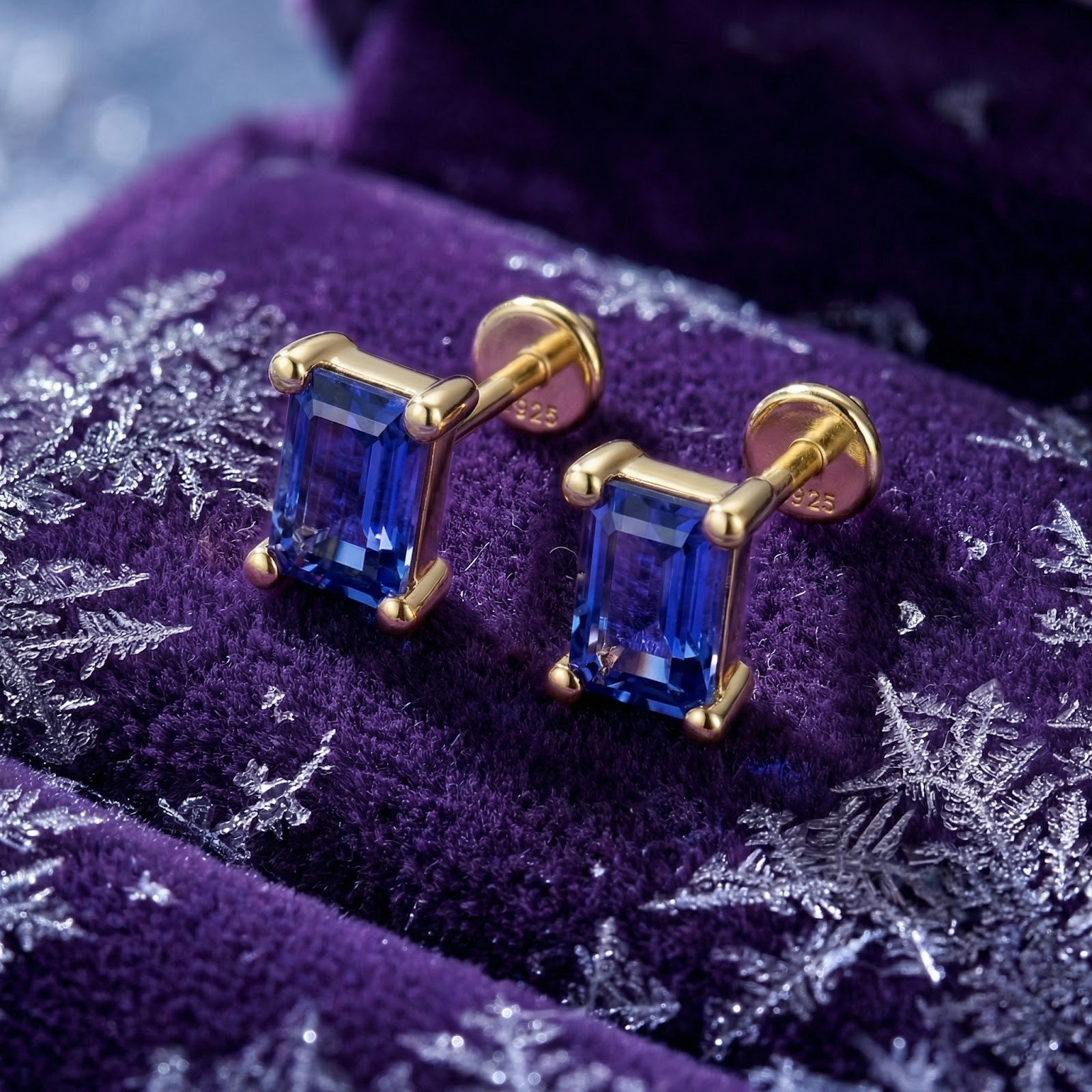 Close-up of emerald-cut simulated tanzanite earrings in 18K gold vermeil showing the S925 sterling silver hallmark.