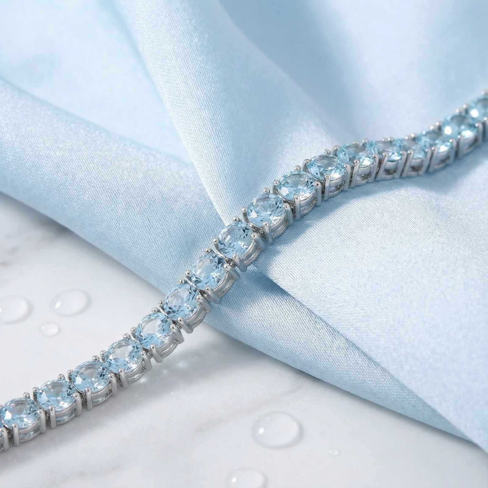 Macro view of round simulated aquamarine stones in a stainless steel tennis bracelet setting.