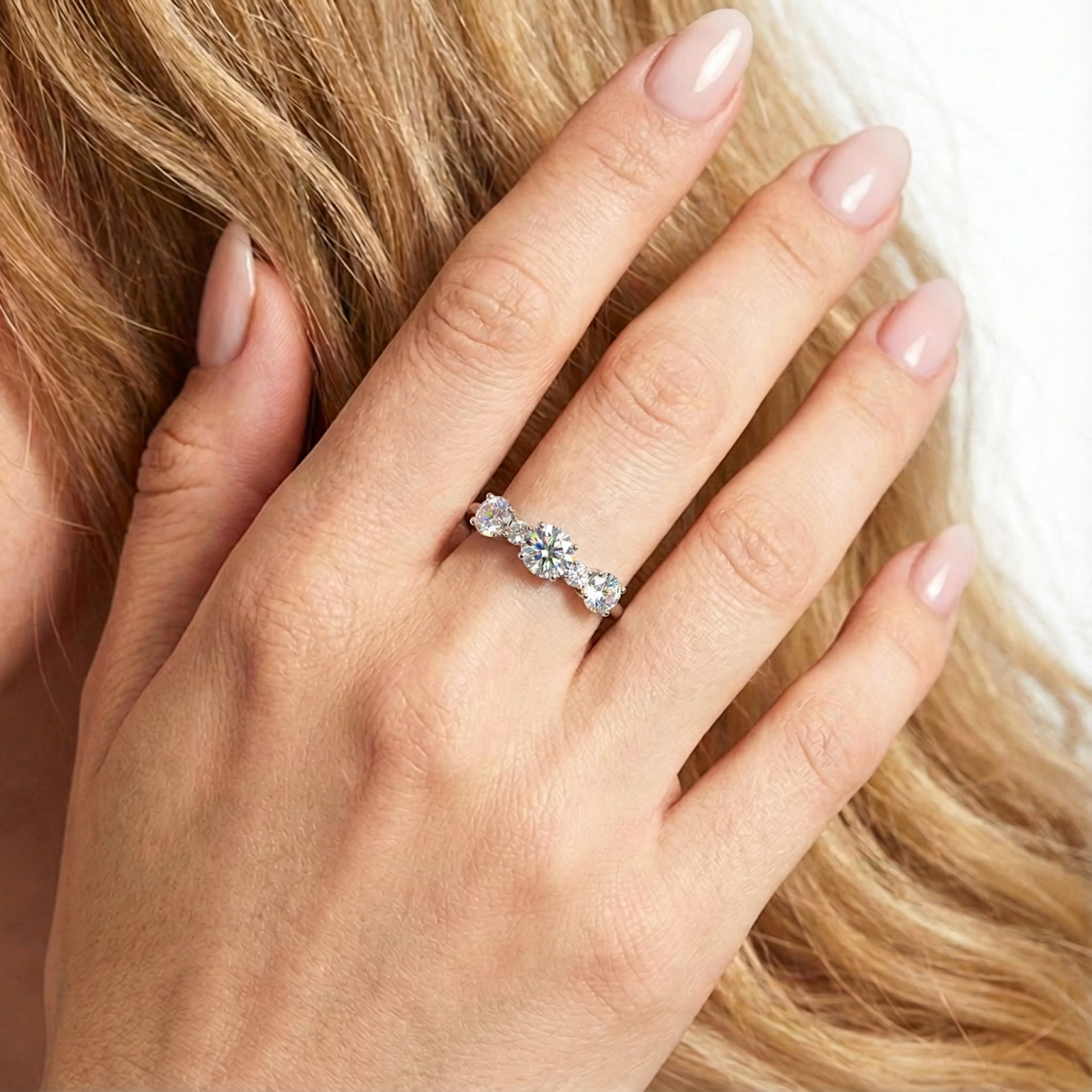 Top view of the Elianne silver ring with round cut zirconia stones worn on a hand to show size and scale.