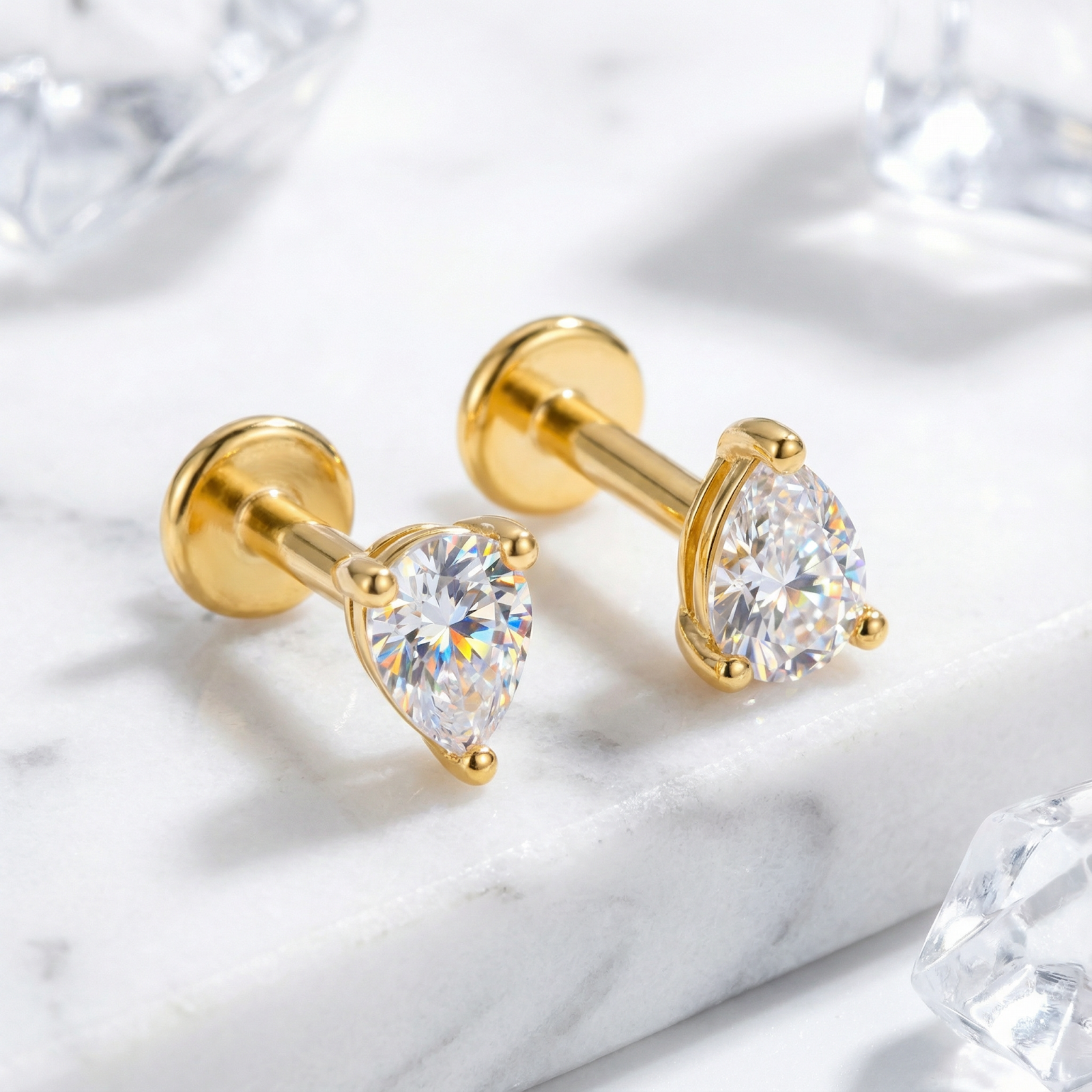 Close-up of pear-cut simulated diamond stud earrings in 18K gold vermeil showing the flat back and prong setting.
