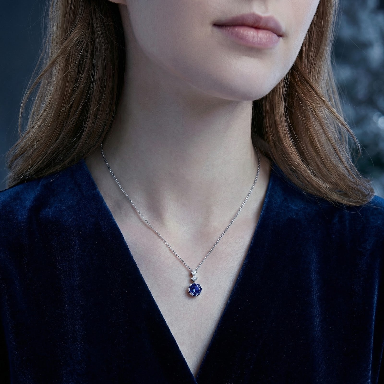Model wearing the Amaryllise simulated tanzanite pendant in sterling silver on a delicate chain.