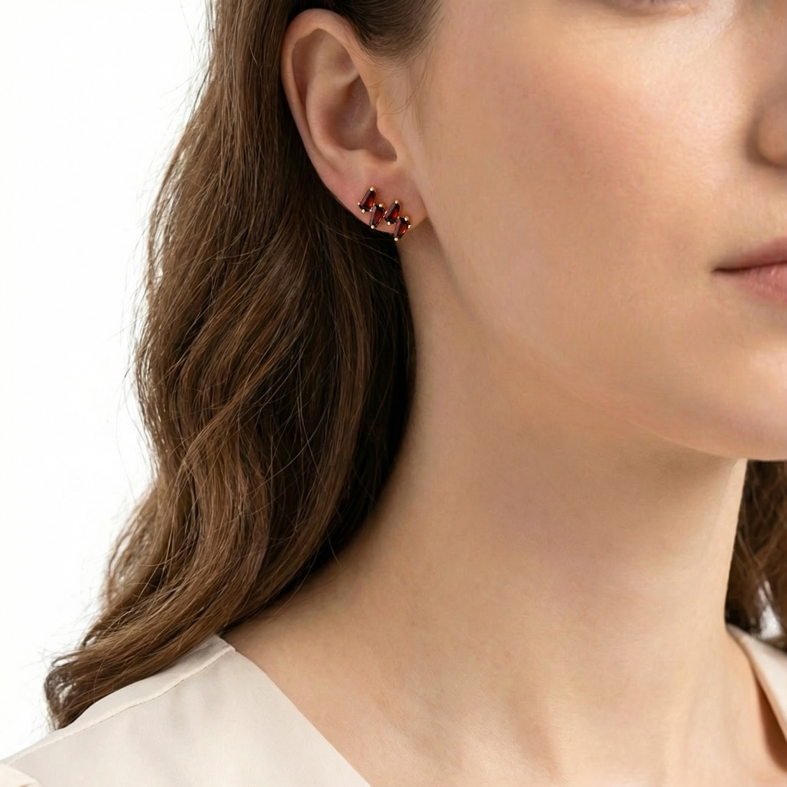 Side view of a model wearing the Aethelra red simulated garnet cluster earring in 18K gold vermeil.