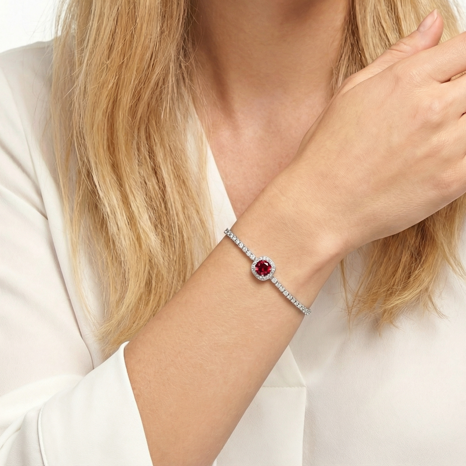 A sterling silver simulated ruby halo bracelet shown on a model's wrist.