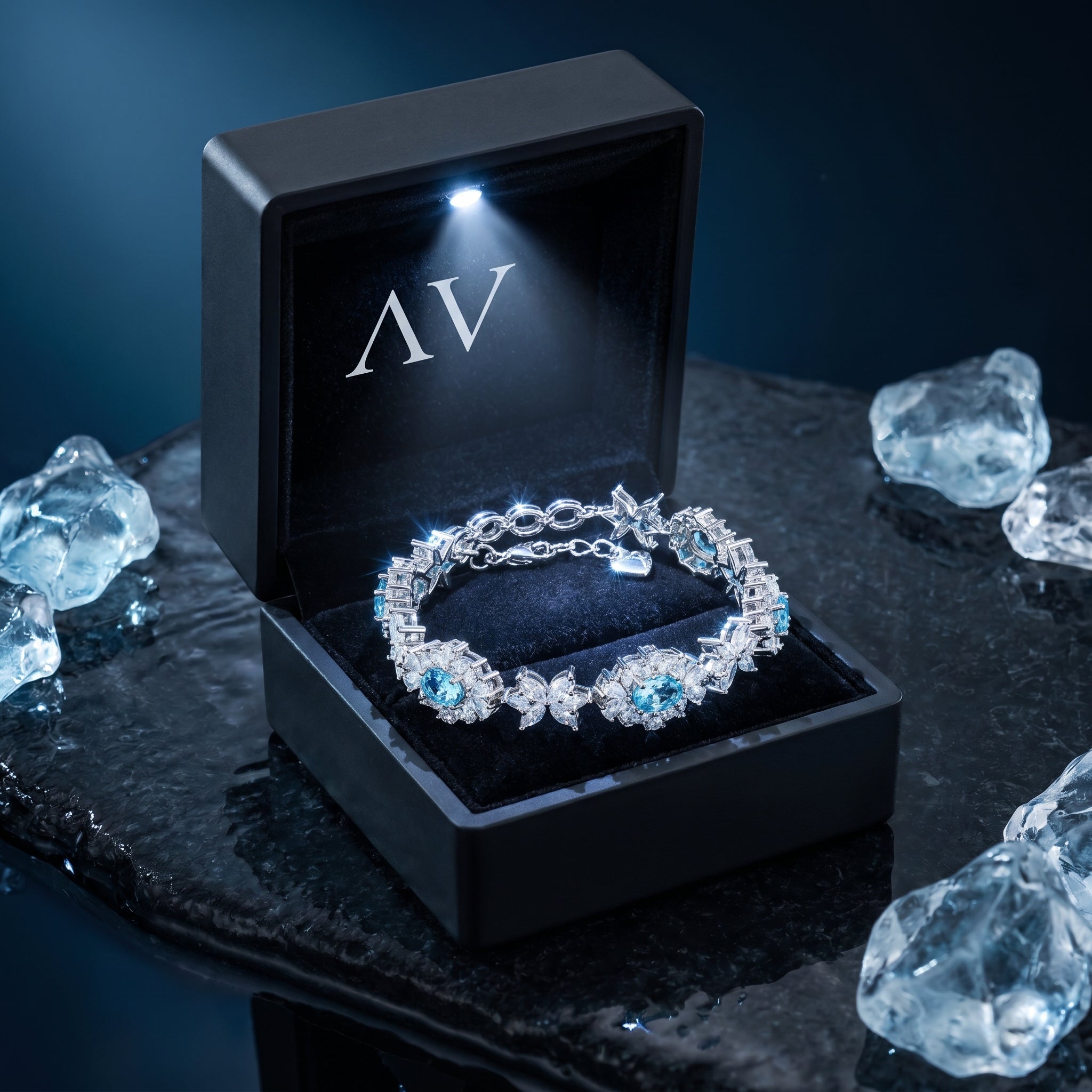 Silver aquamarine station bracelet presented in a black LED-lighted gift box on a dark surface.