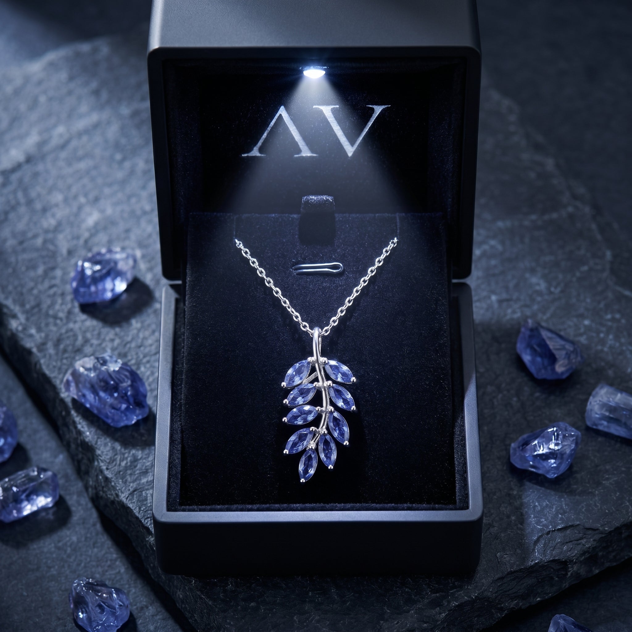 Laurelia marquise tanzanite necklace in white gold inside a lighted black gift box with raw tanzanite stones.