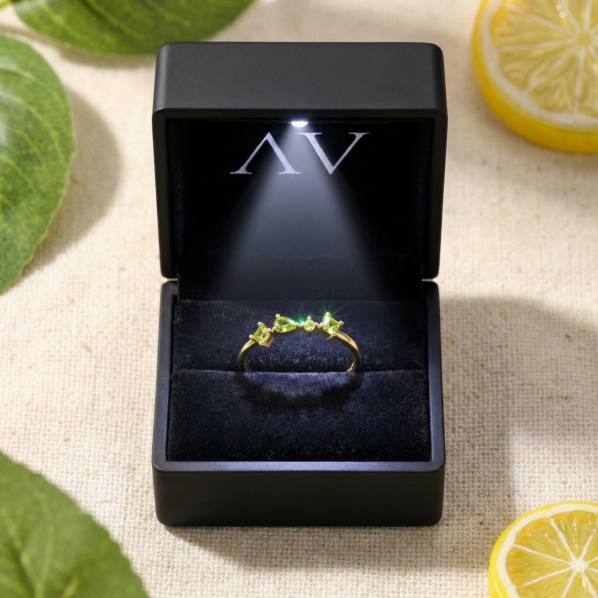 18K gold vermeil peridot ring presented in a black LED-lit jewelry box with the AV logo.