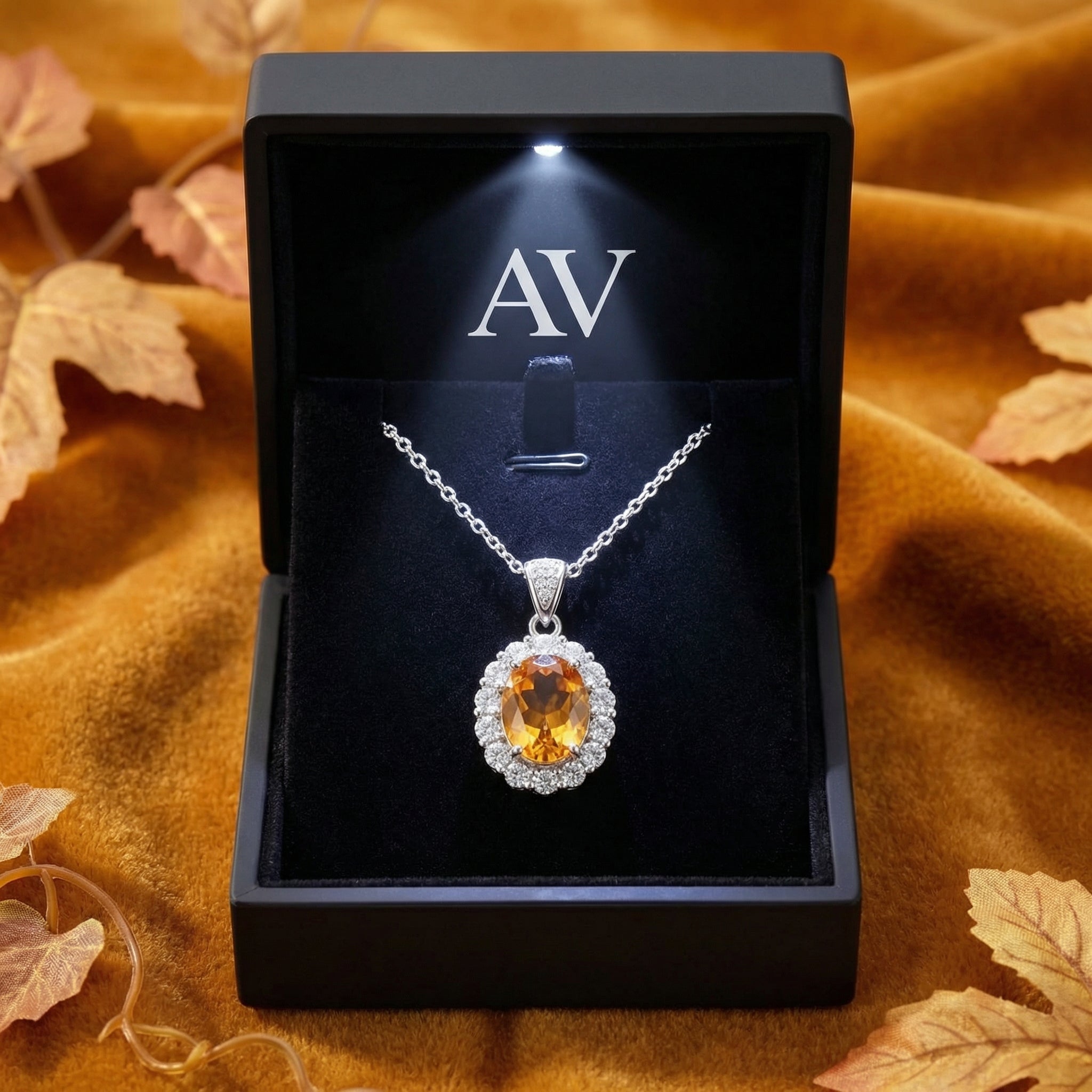 Honeyed oval topaz sterling silver necklace in a black LED-lit jewelry box on orange velvet.