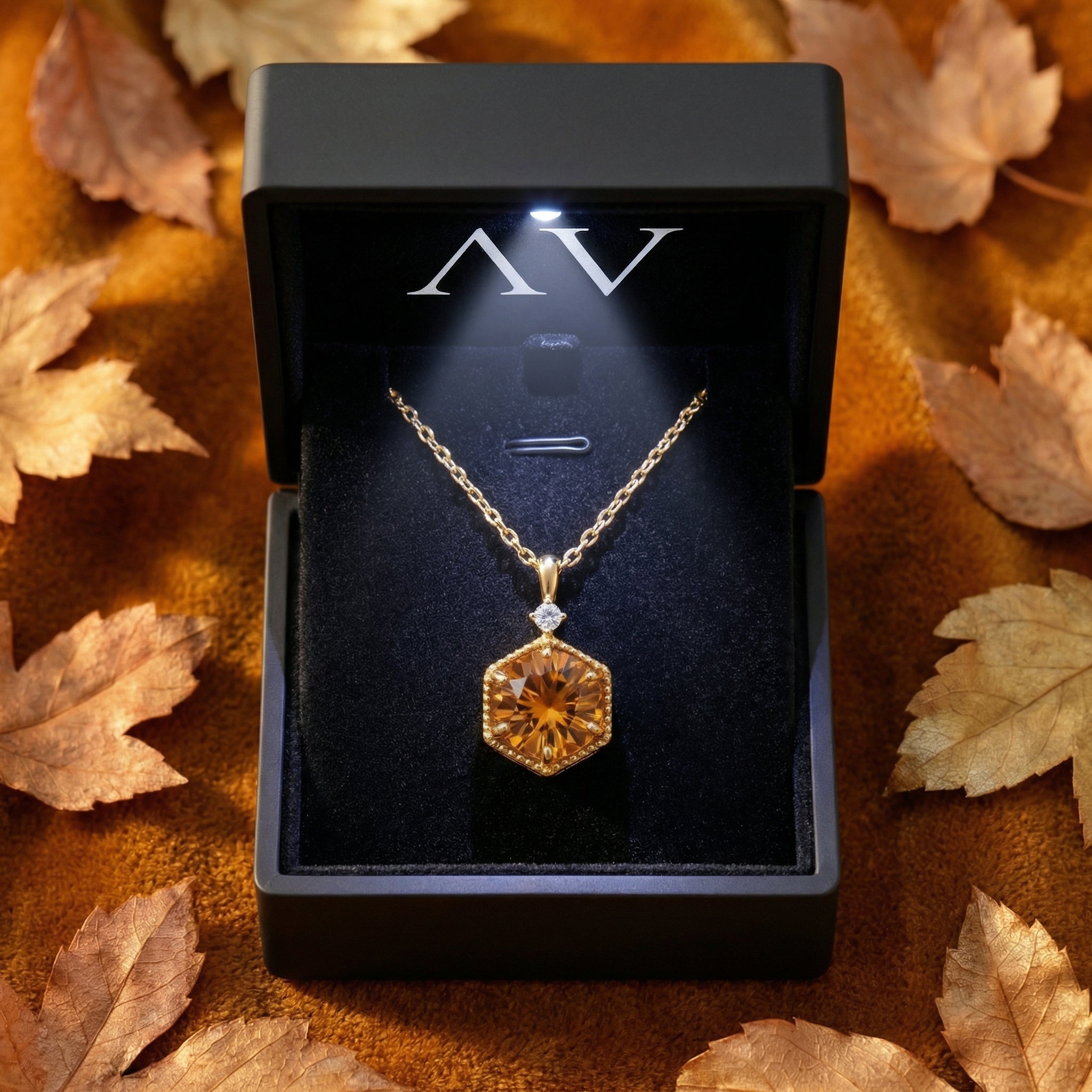Hexagon-cut simulated topaz necklace in 18K gold vermeil inside a black LED-lit gift box with autumn leaves.