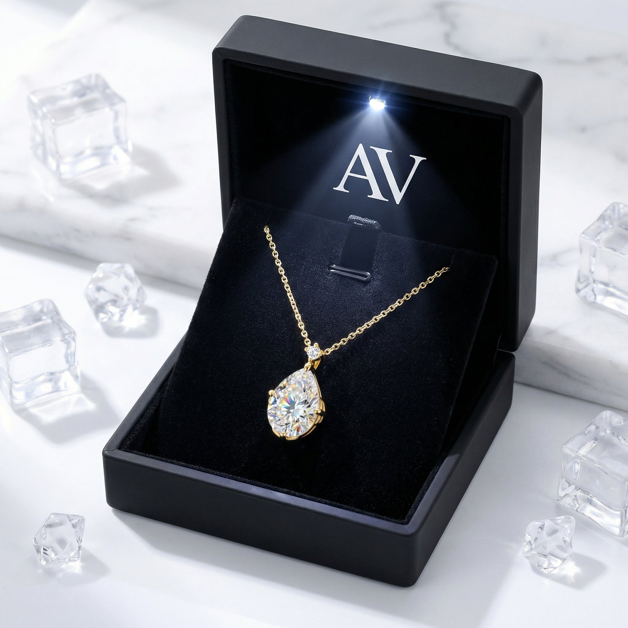18K gold vermeil pear-cut zirconia necklace presented in a black LED-lit gift box on a marble surface.