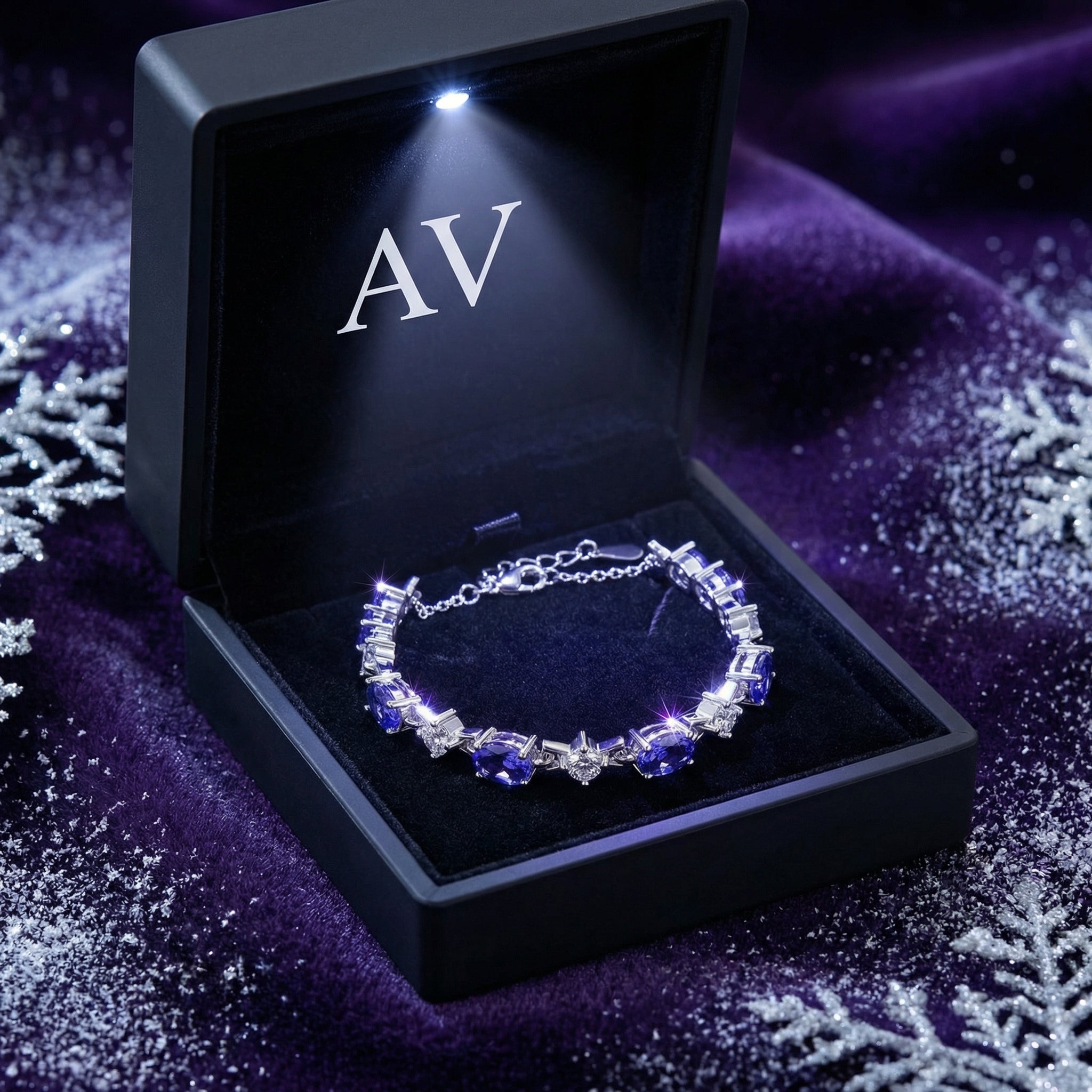 Sterling silver Zenelle station bracelet with oval-cut simulated tanzanite in a lighted black jewelry gift box.