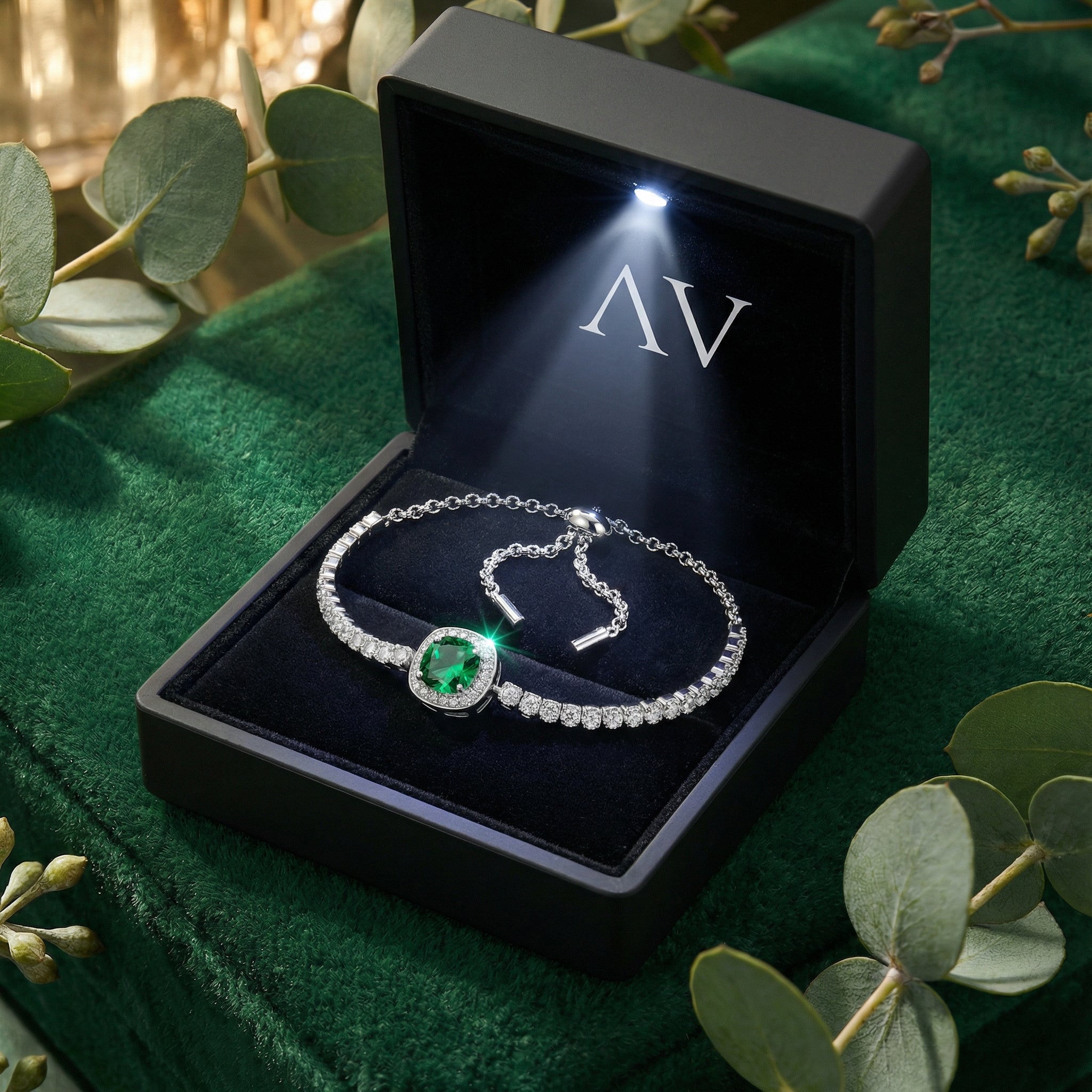 Sterling silver simulated emerald bracelet in a black LED-lit gift box on green velvet.