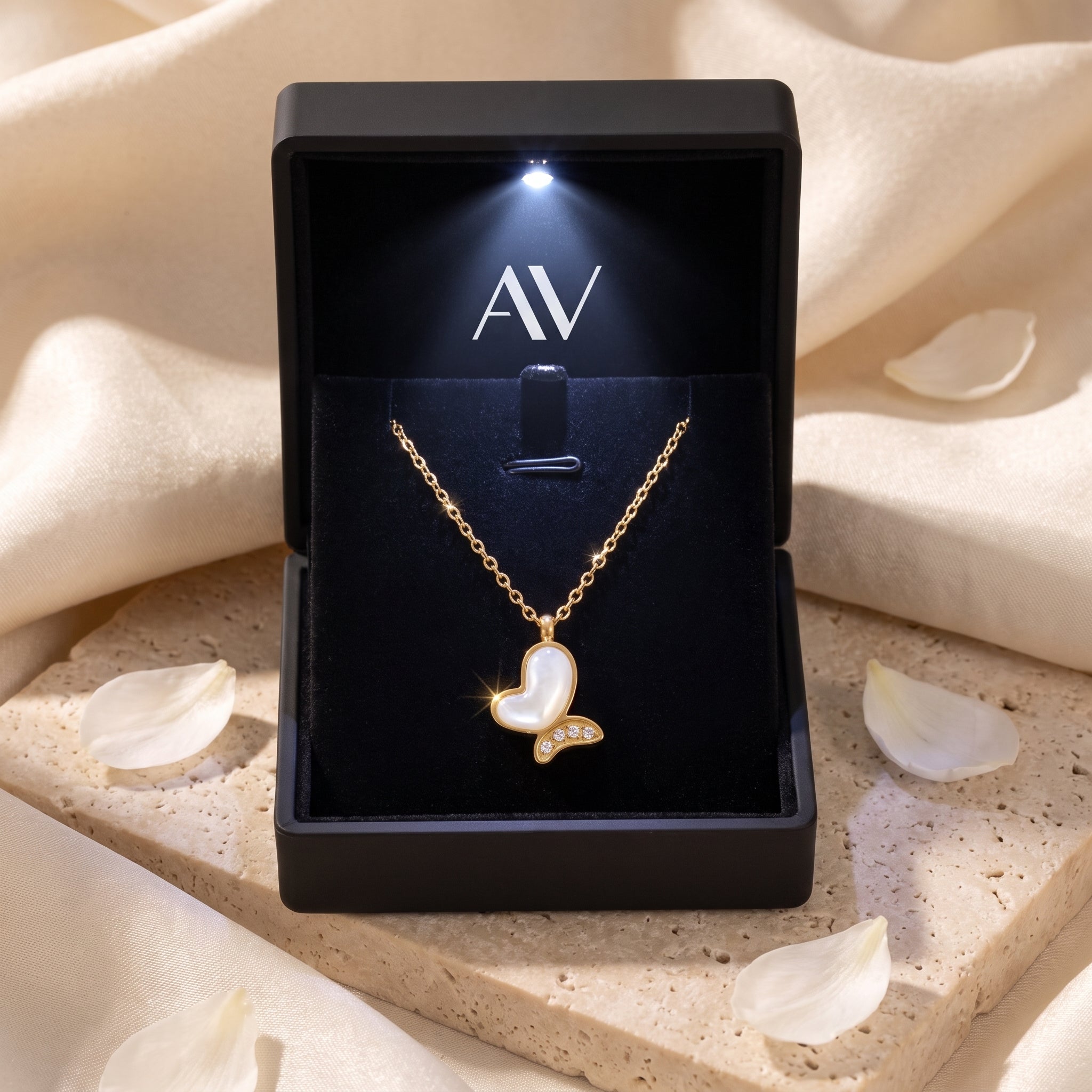 Gold mother of pearl butterfly necklace displayed in a black LED-lit jewelry gift box.