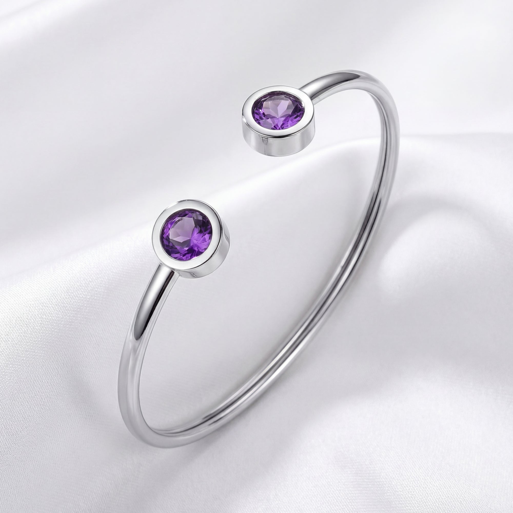 Silver stainless steel Liora open-cuff bracelet with round simulated amethyst stones on white silk.