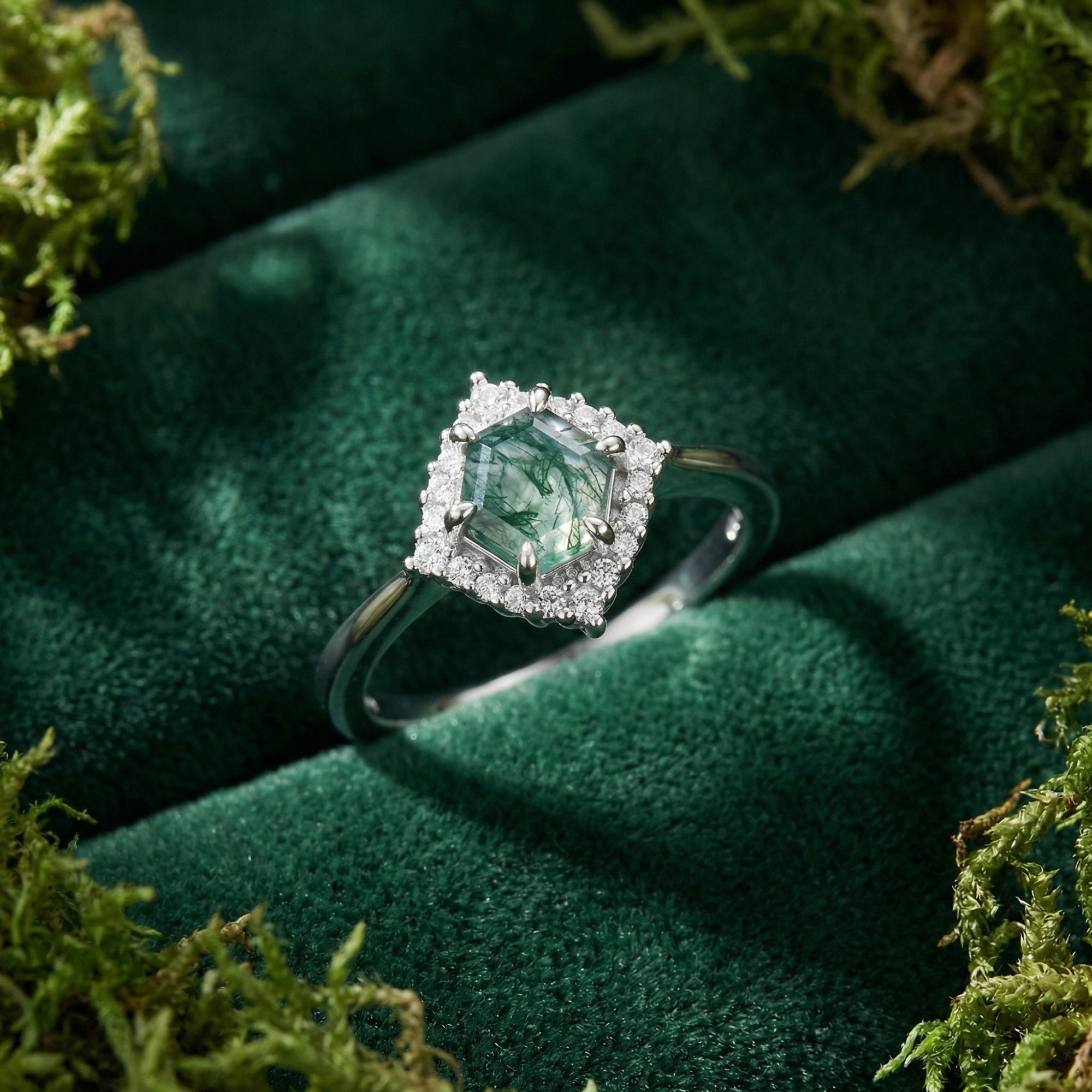 Hexagonal moss agate ring in S925 sterling silver with diamond halo on green velvet and moss.