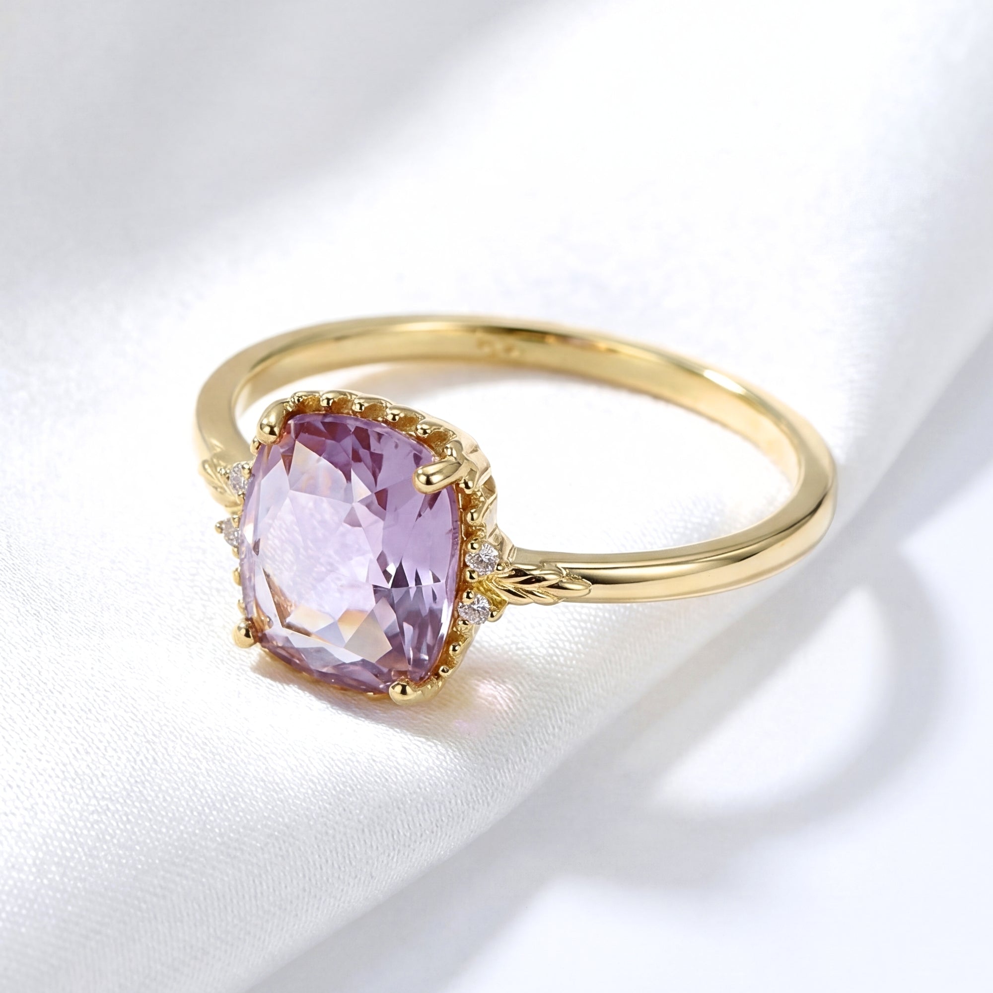 Angled view of the cushion cut simulated amethyst solitaire ring in 18K gold vermeil on white silk.
