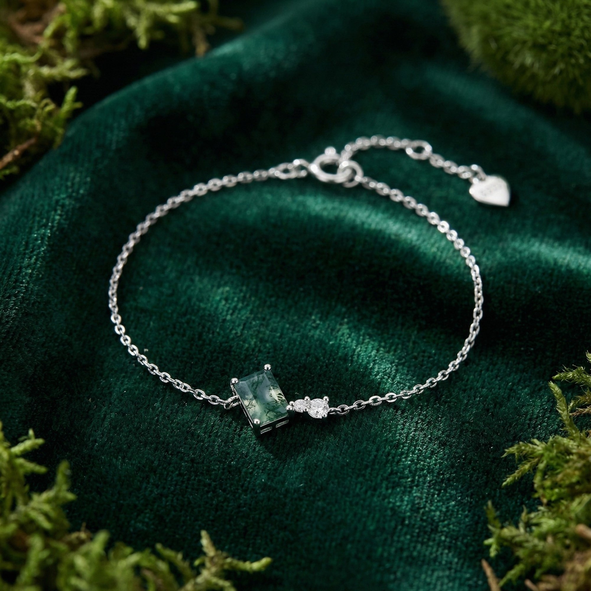 Square cut natural moss agate charm bracelet in S925 sterling silver on green velvet with moss accents.