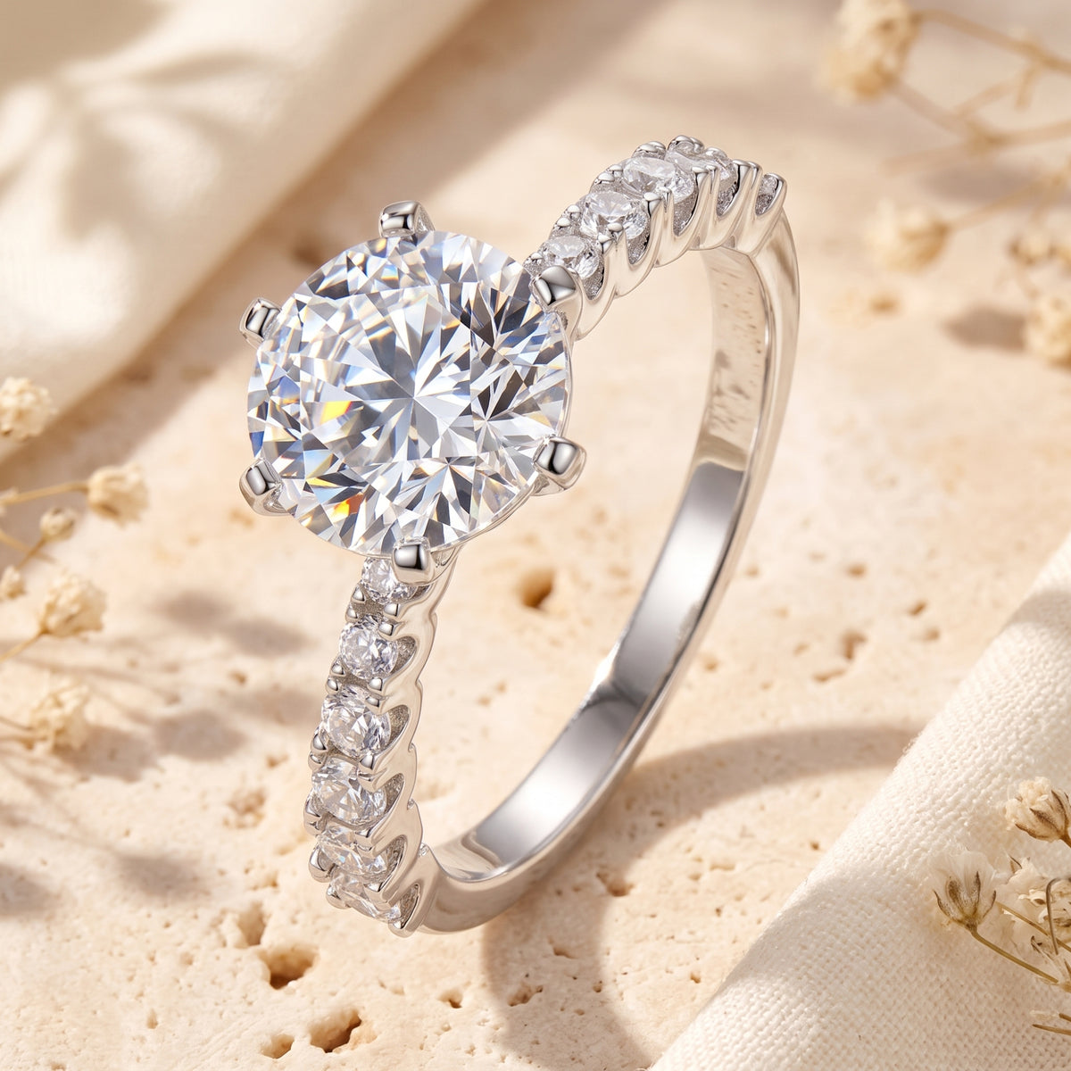 Close-up of the silver ring featuring a round clear center stone in a six-prong setting with a stone-accented band.