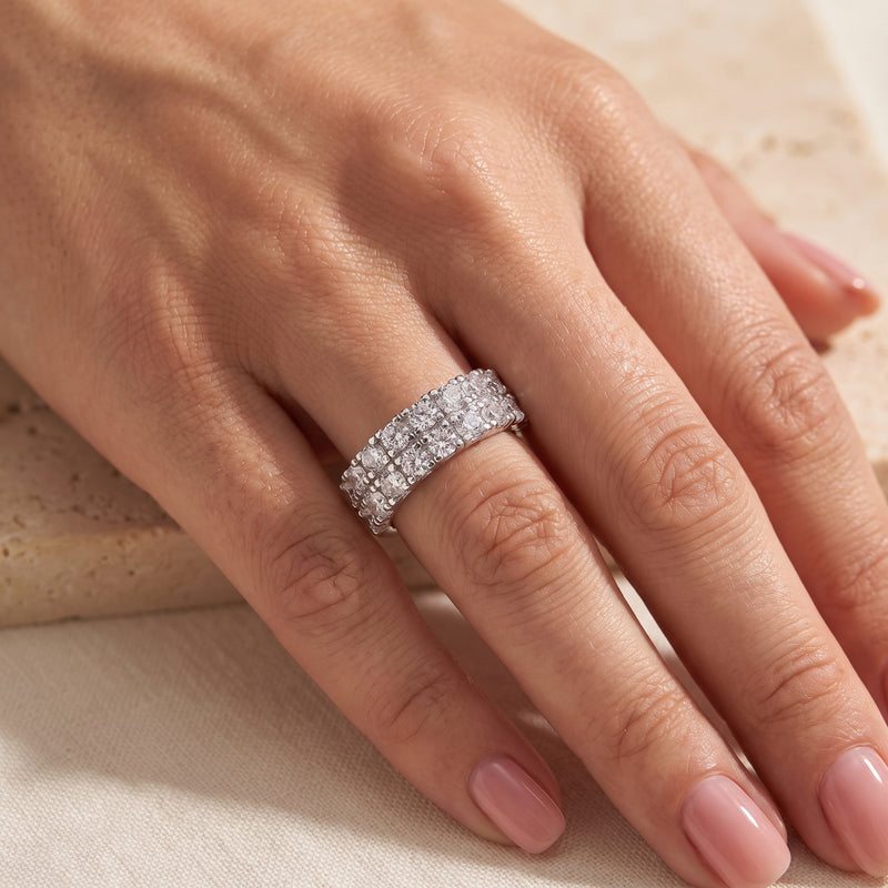 On-model view of the silver band ring with two rows of clear stones worn on a ring finger.