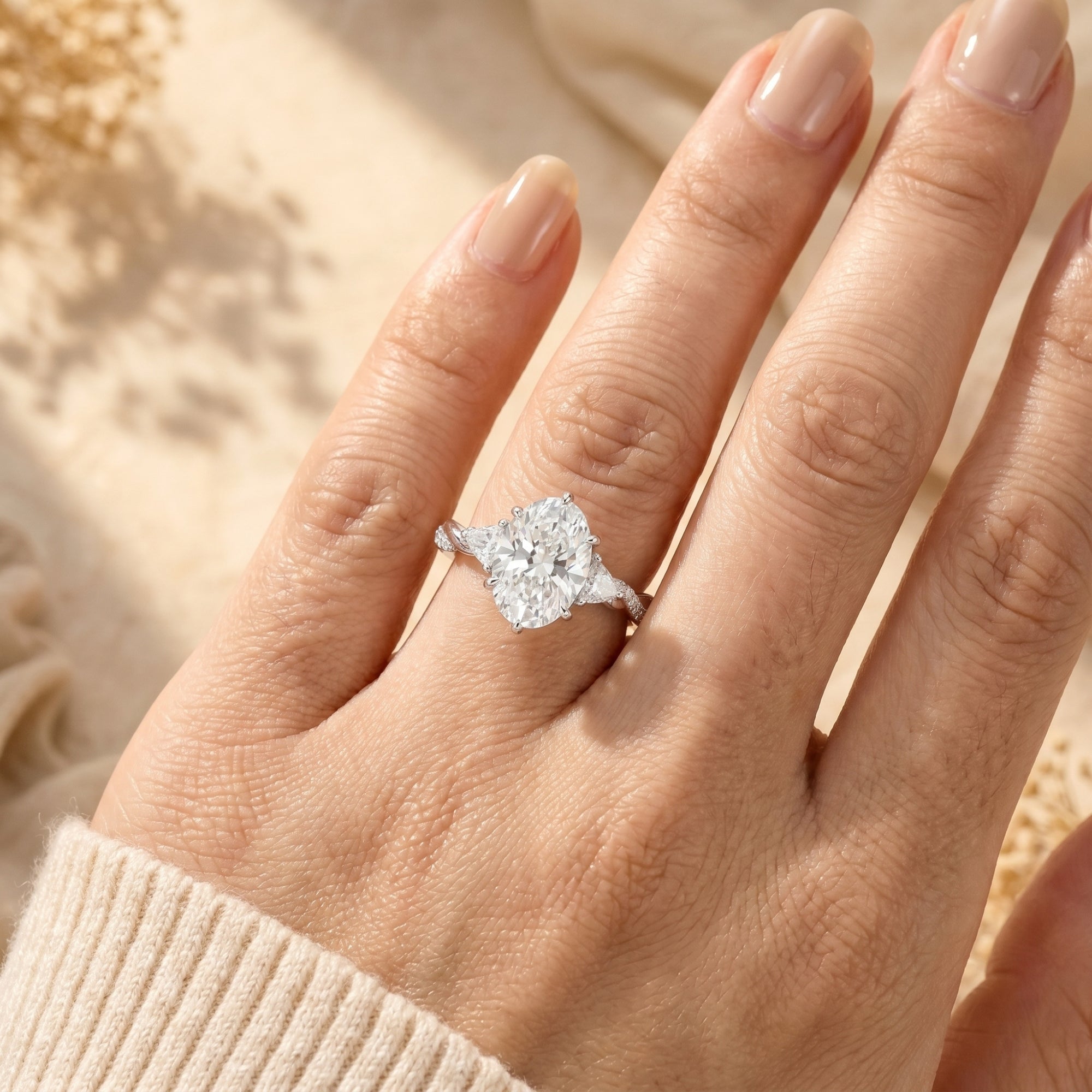 Oval cut moissanite promise ring in silver worn on a woman's finger to show 3-carat scale.