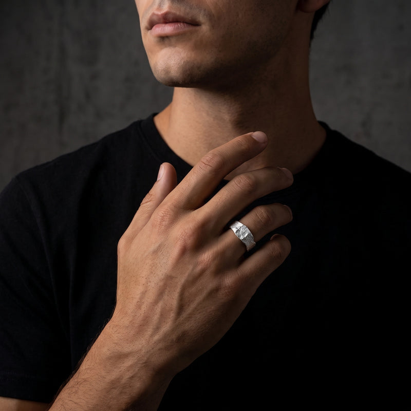 Male model wearing the molten textured silver open ring on his ring finger.