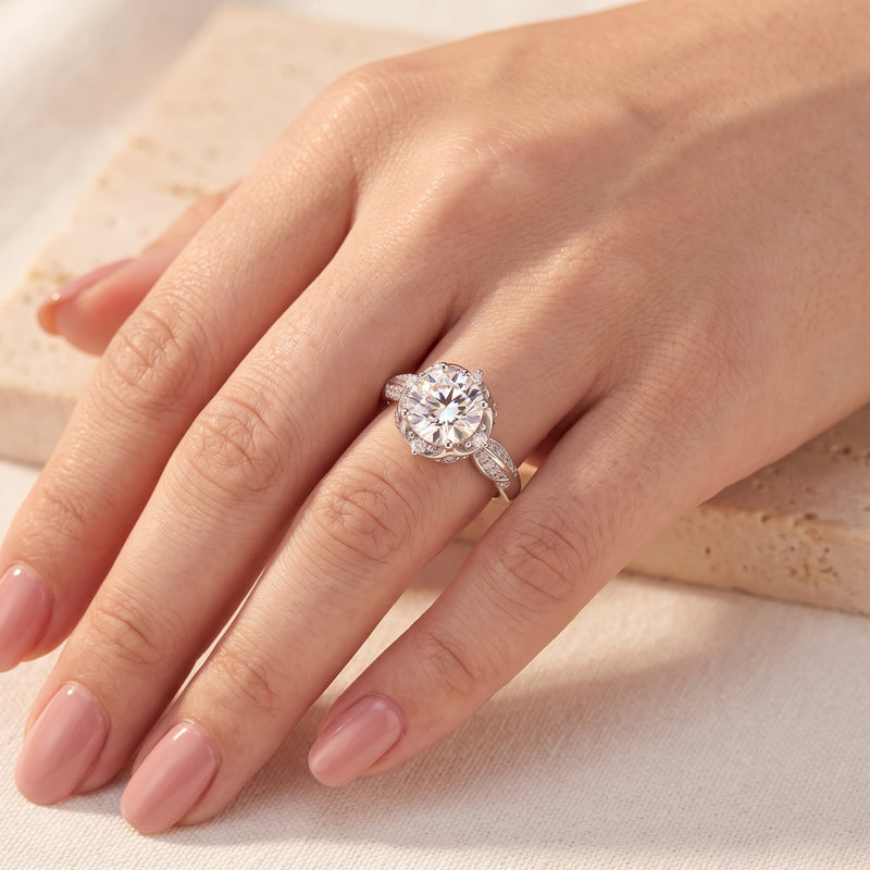 Top-down view of the silver lotus solitaire ring worn on a ring finger with manicured nails.