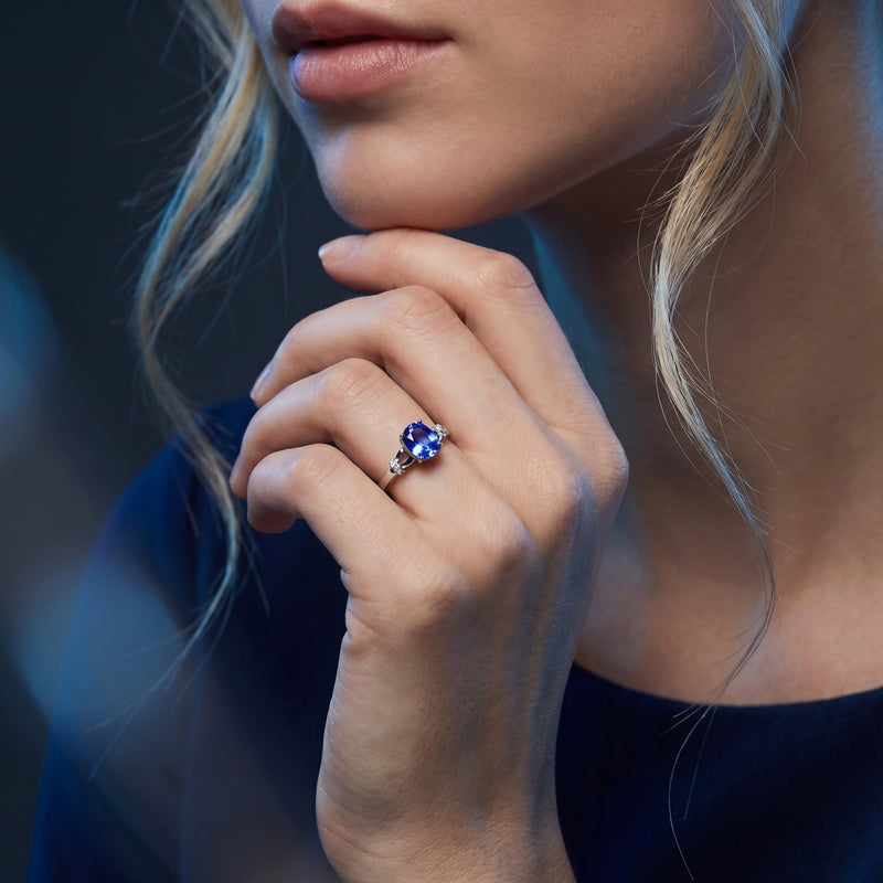 The Illiana oval tanzanite ring in 18K white gold worn on a model's hand to show scale and color.